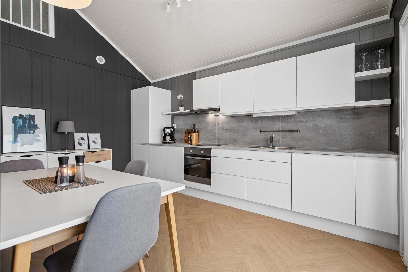 Kjøkkeninnredning med glatte fronter, laminert benkeplate og integrerte hvitevarer. Galleribilde