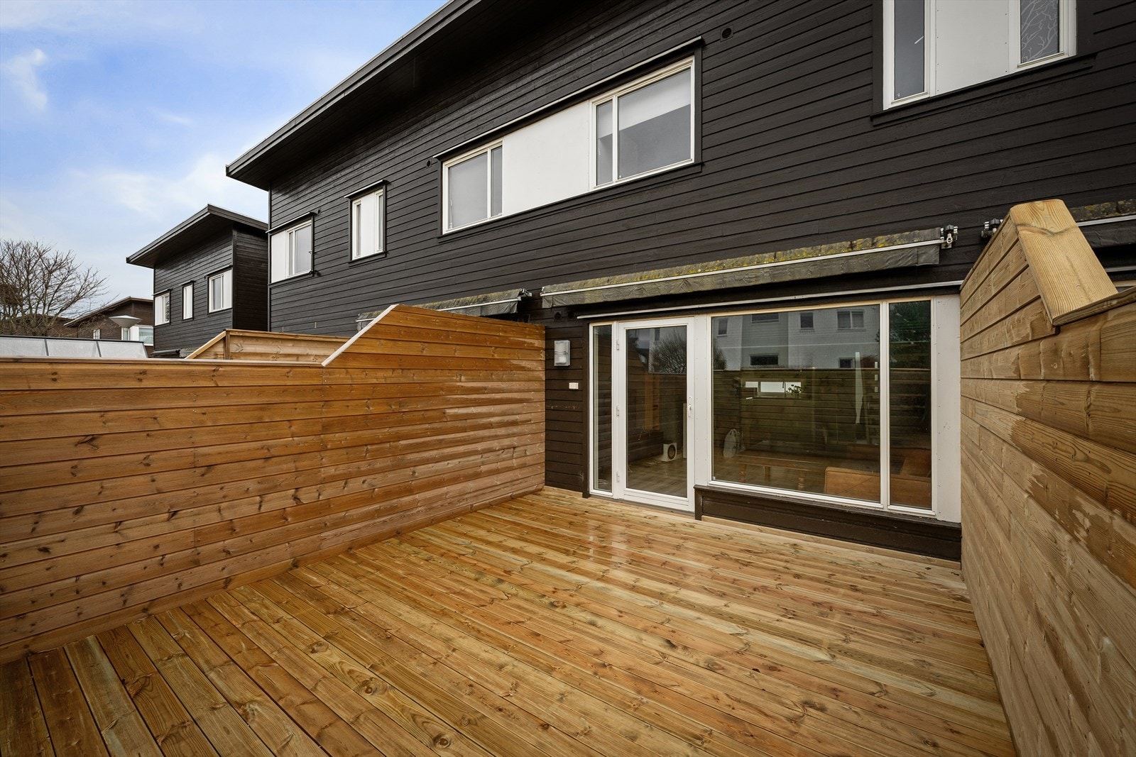 Terrassen på cirka 20 m² er bygget i impregnert tre og har levegger som gir en privat uteplass. Galleribilde