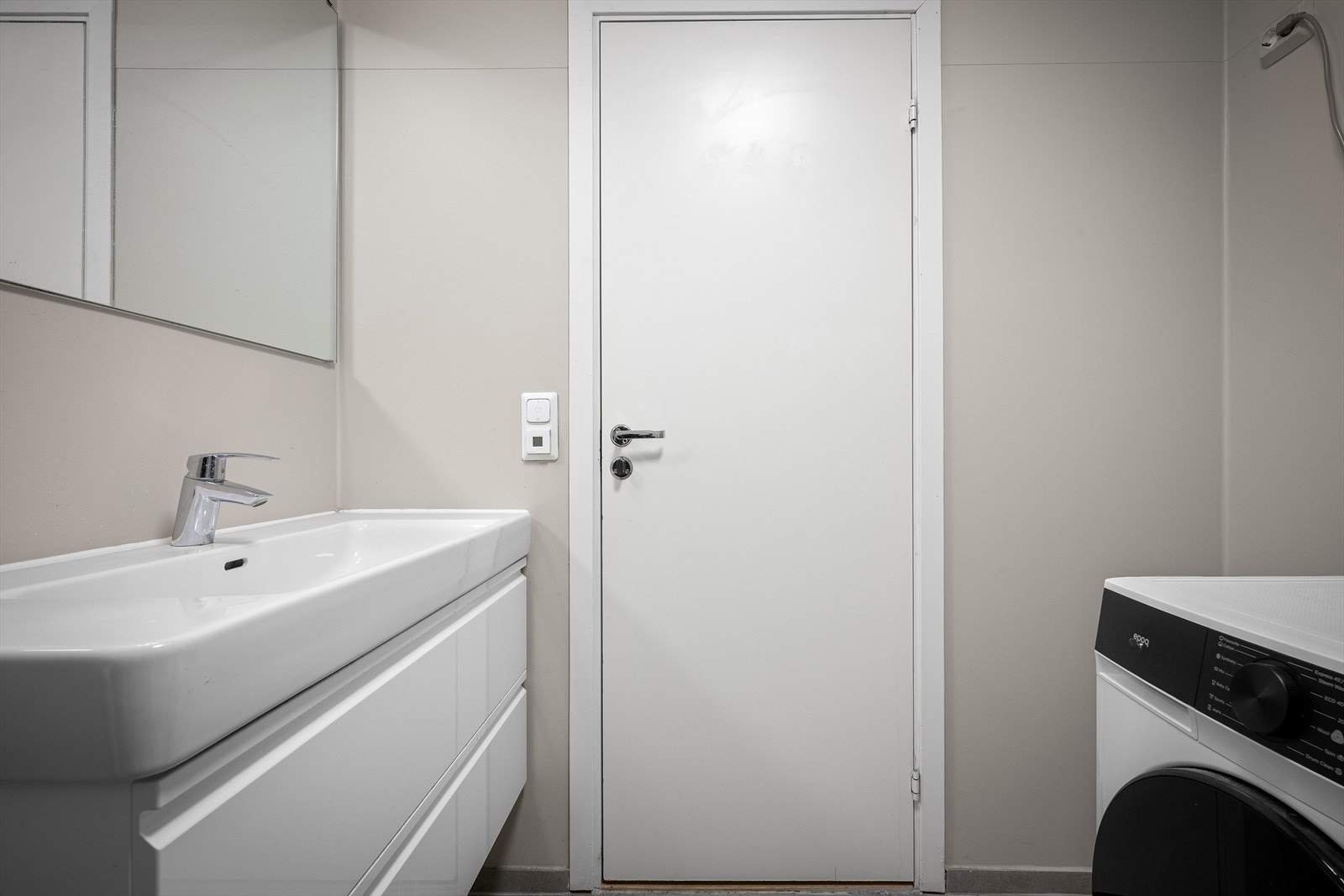 Rommet er kombinert vaskerom med opplegg for vaskemaskin og har en praktisk servantinnredning. Galleribilde