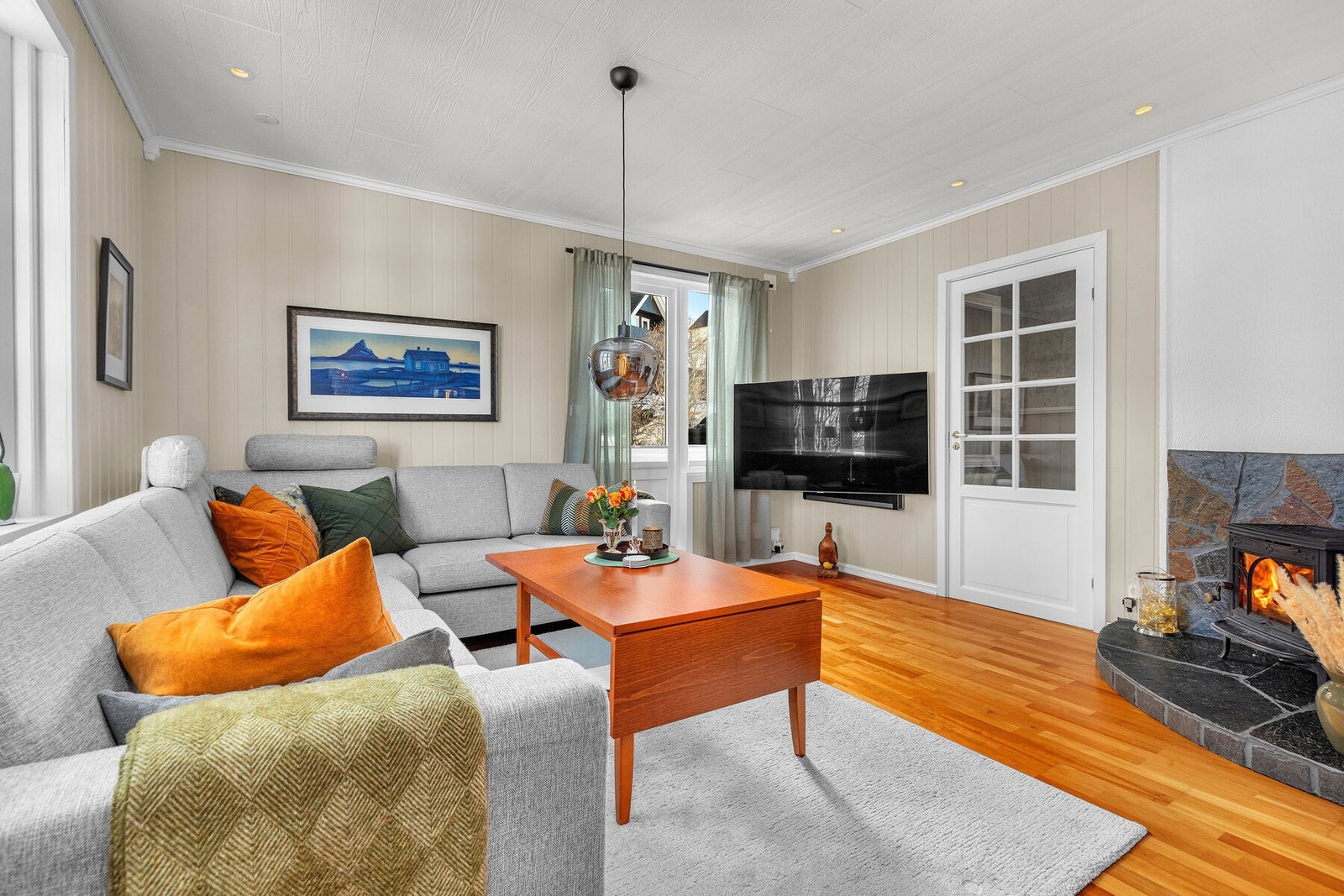 Stue med fin utsikt, parkett på gulv, vedovn og spotter tak Galleribilde