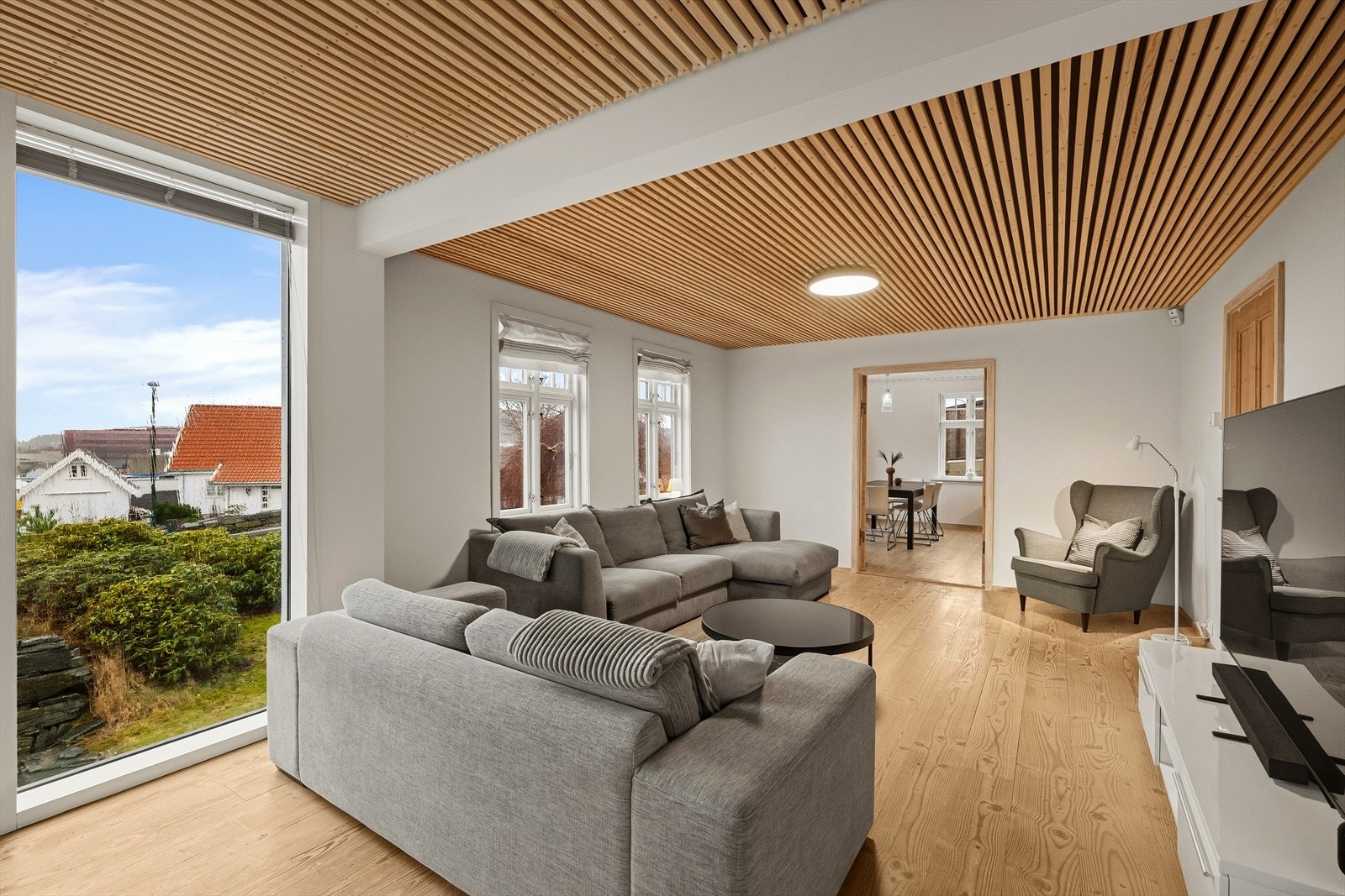 Åpen og fin stue med spiletak og store vindusflater Galleribilde