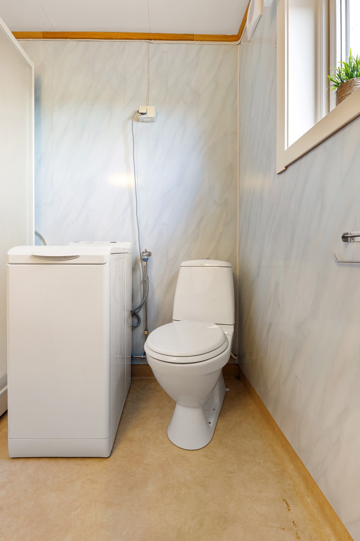 Badet er praktisk innredet med baderomsplater på veggene, himlingsplater i taket og vinylbelegg på gulvet. Galleribilde