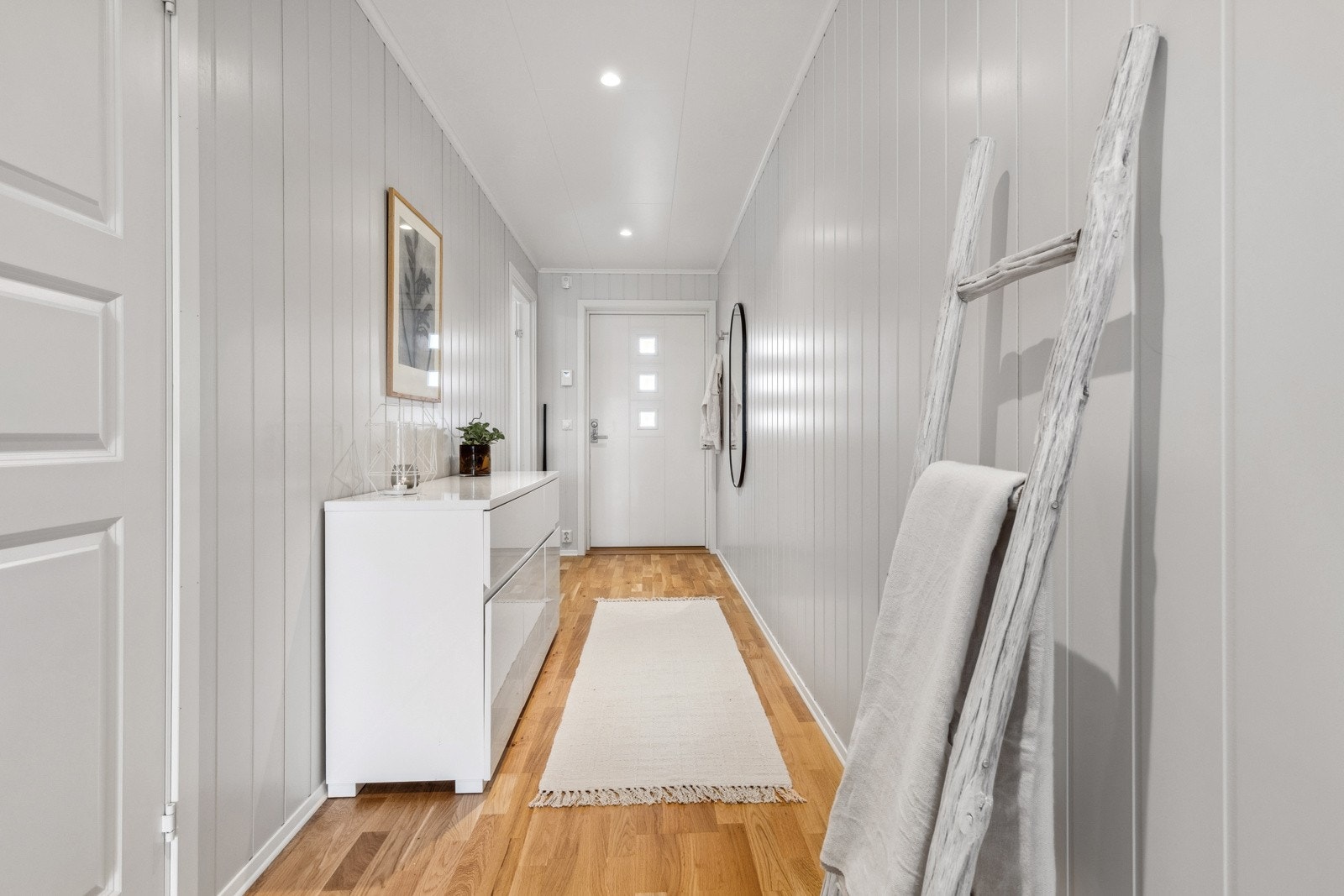 Lys entre/gang med trestavs parkett på gulv og lysmalt smartpanel på veggflater som gir et godt førsteinntrykk av leiligheten. Himlingen er pent lyssatt med LED dowlights. Galleribilde