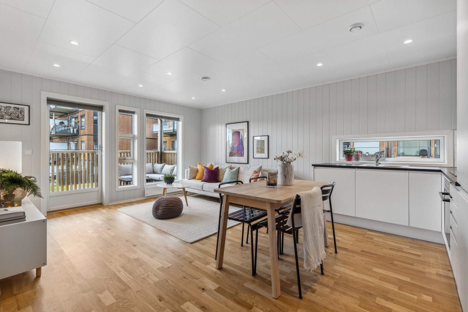 Den åpne stuen fremstår som meget innbydende i lyse, tidsriktige fargevalg. Store vindusflater slipper inn rikelig med lys og gir en luftig romfølelse. Galleribilde