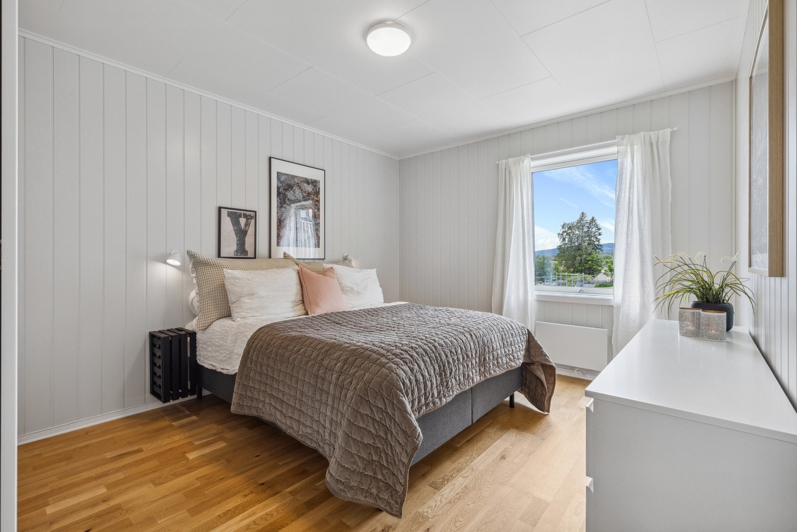 Hovedsoverommet har god plass til dobbeltseng og tilhørende nattbord. Rommet har lysmalt smartpanel på veggflater, trestavs parkett på gulv og et stort vindu som slipper inn rikelig med lys. Galleribilde