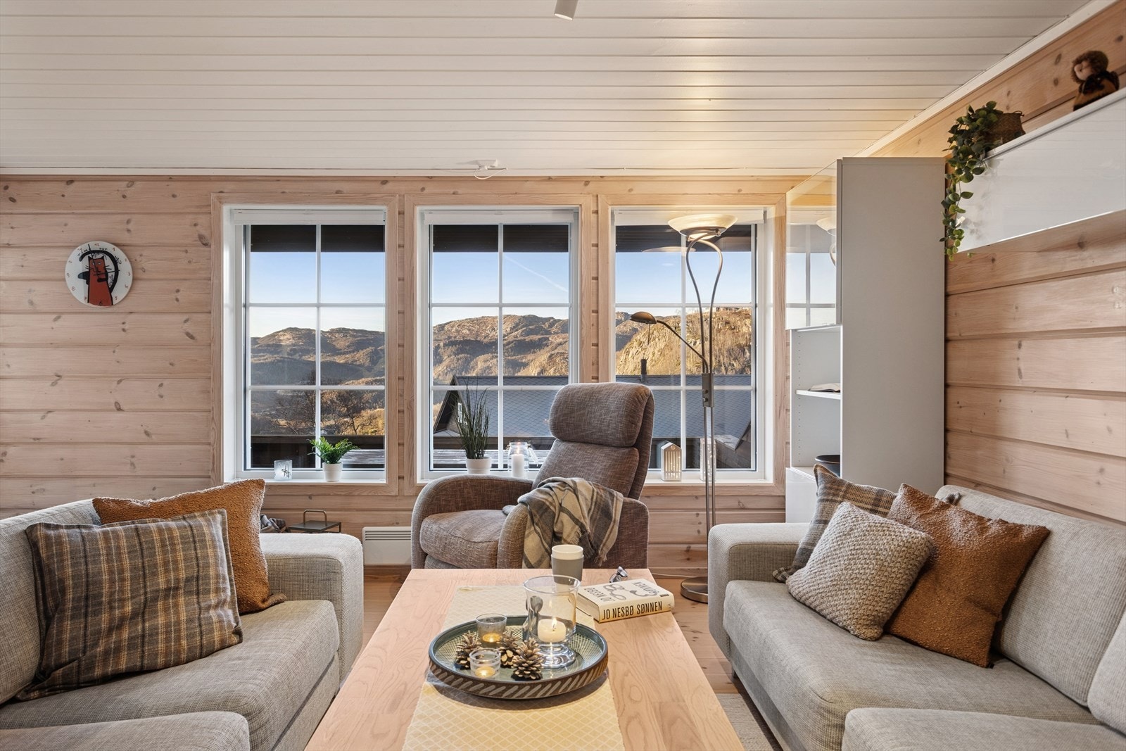 Den lyse, men samtidige lune stuen har store vinduer som slipper inn rikelig dagslys og gir nydelig utsikt mot fjellene. Galleribilde