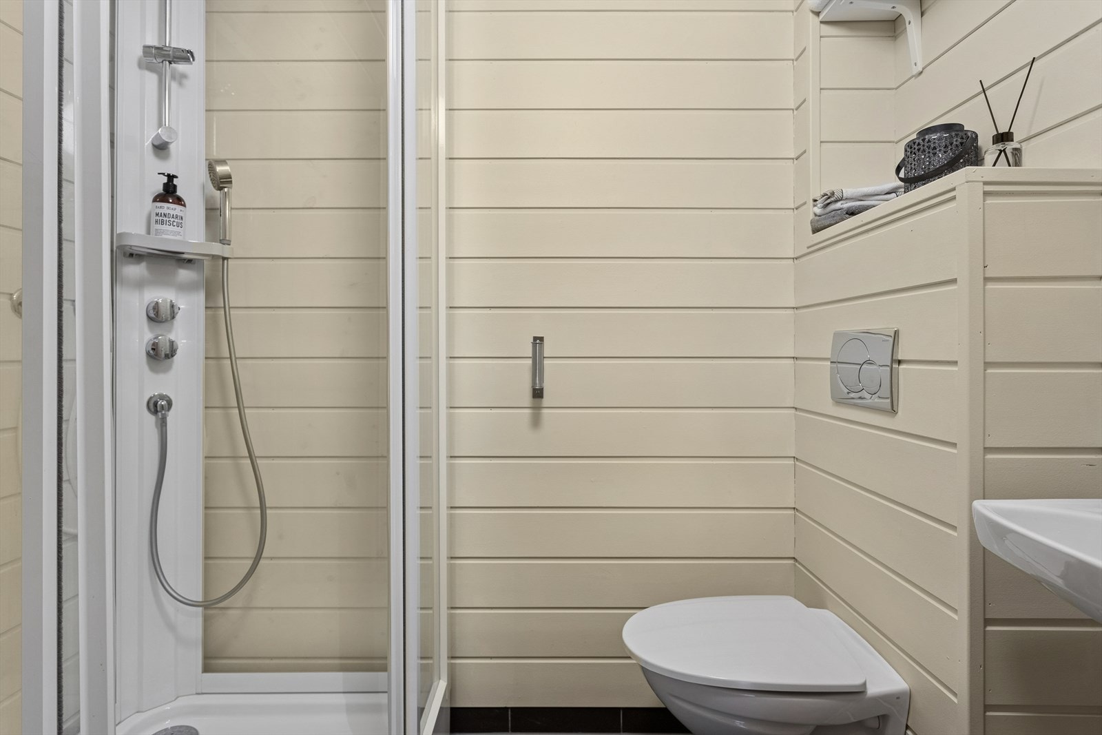 Badet i loftsetasje er utstyrt med vegghengt servant, veggmontert toalett og dusjkabinett. Galleribilde