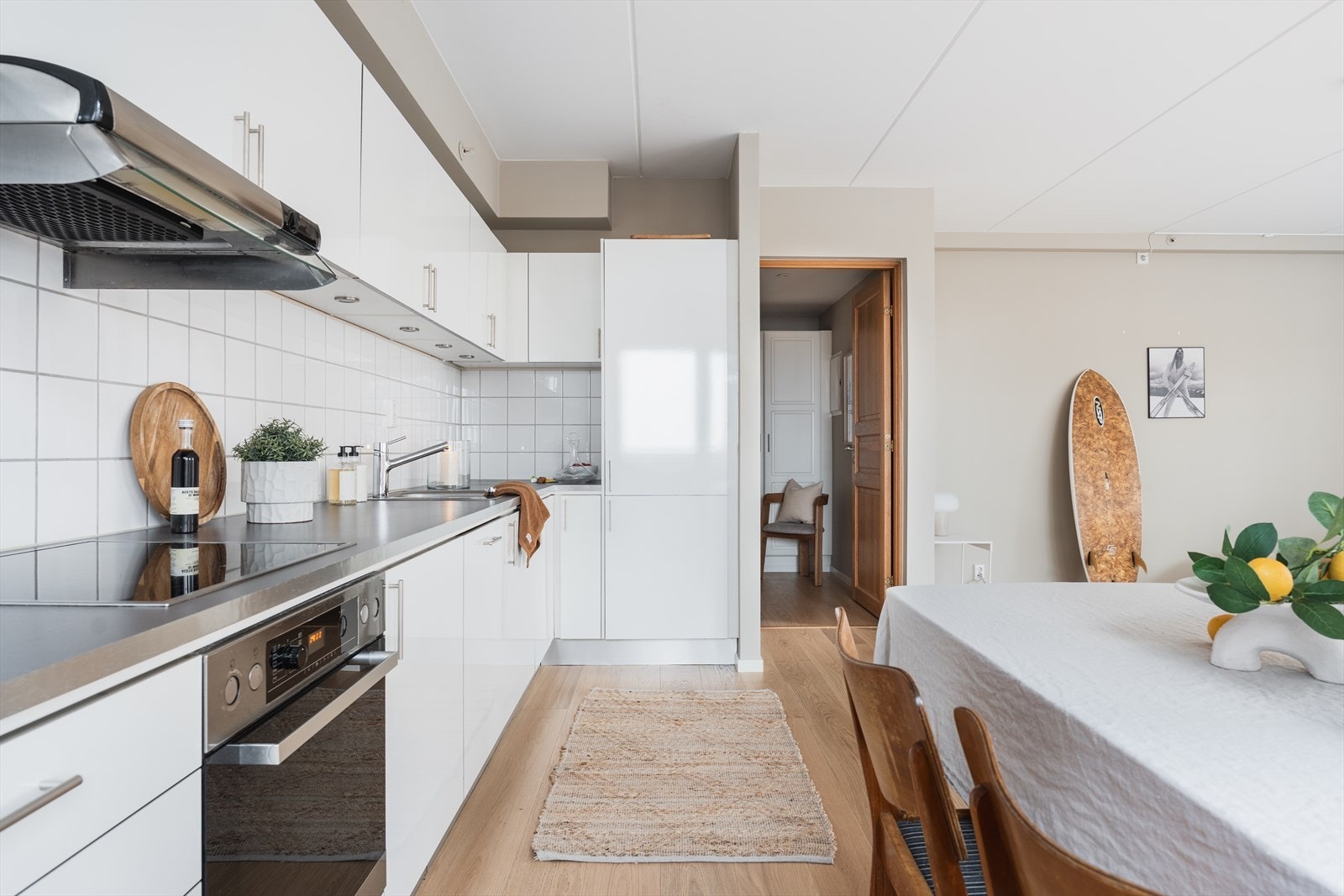 Med høyglansfronter får innredningen et moderne uttrykk, mens laminatbenkeplate og fliser mellom over- og underskap gir en funksjonell og tiltalende helhet. Galleribilde