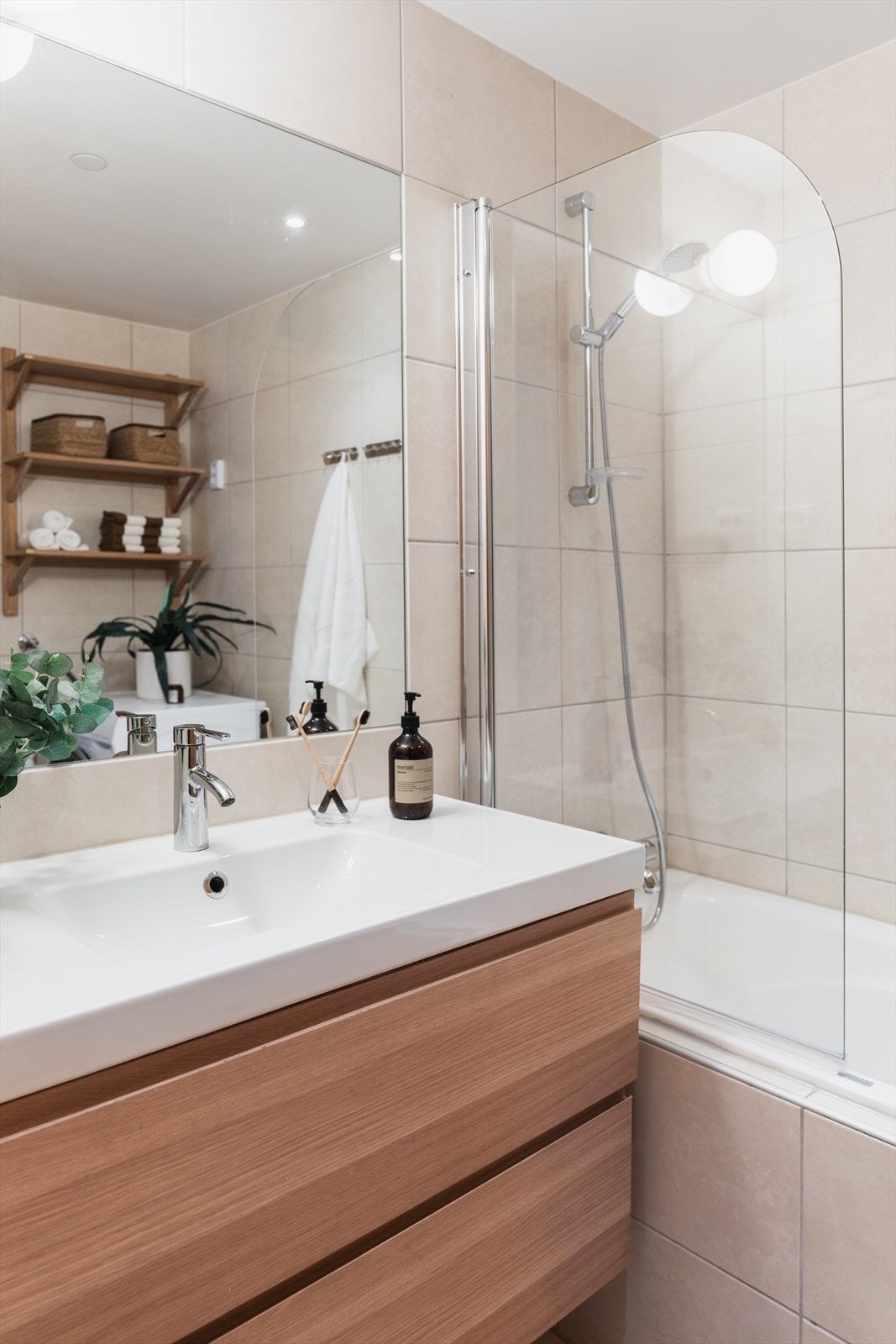 Baderommet har en tidløs utførelse fra byggeår og oppleves både pent og funksjonelt, med flislagte gulv- og veggflater, innfelte downlights og vannbåren gulvvarme. Galleribilde