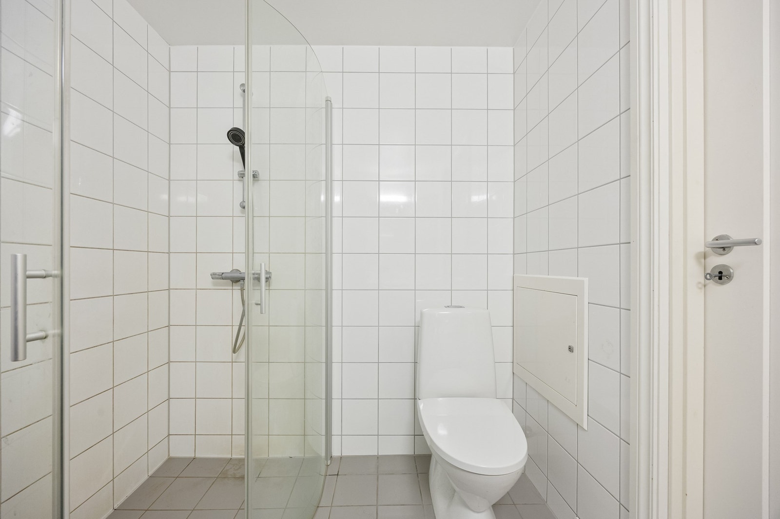 Dusjhjørne med innfellbare glassdører og opplegg for vaskemaskin. Galleribilde