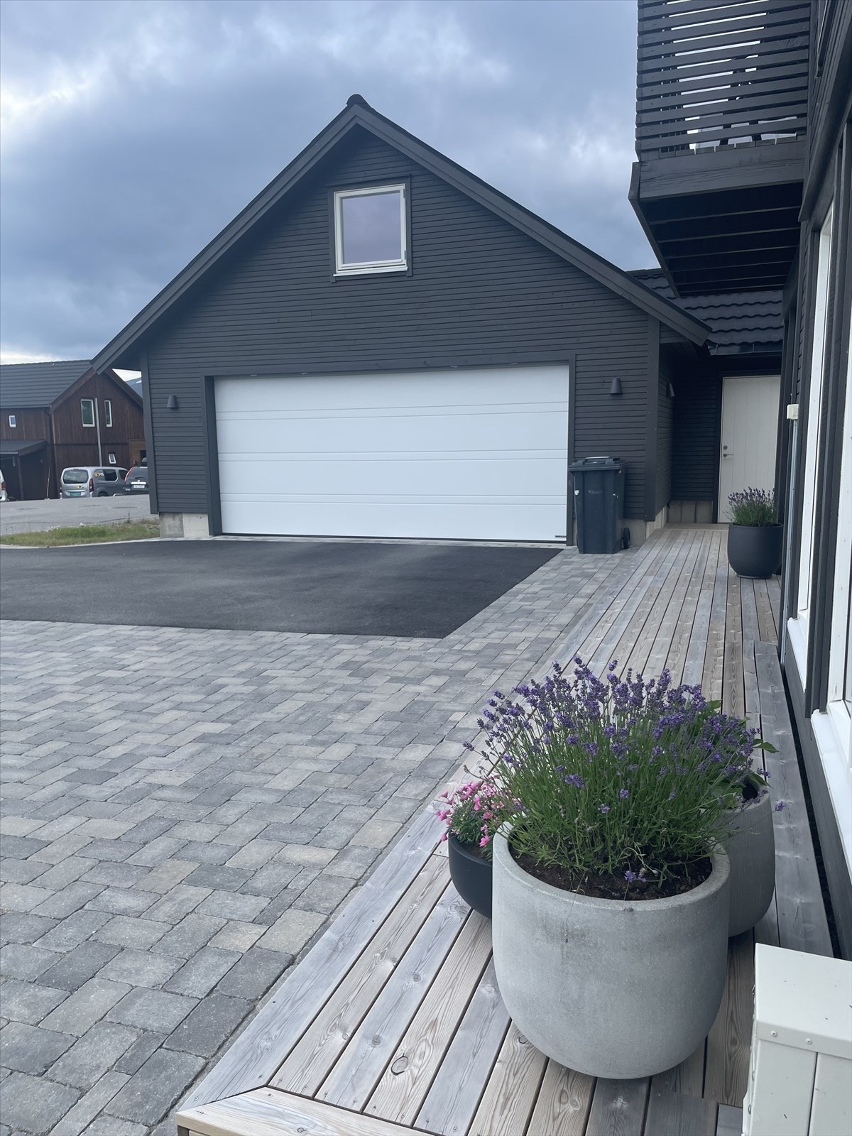 Boligen har gode parkeringsmuligheter på tomt og i frittstående garasje med elbillader, montert i 2021. Galleribilde