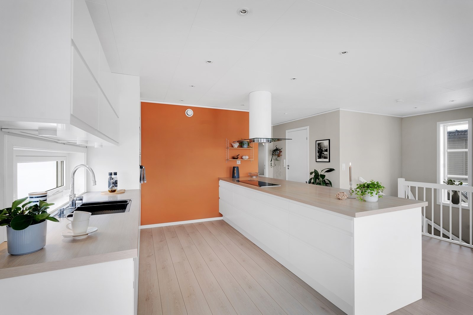 Stilrent og lyst kjøkken med slette fronter og integrerte hvitevarer. Galleribilde