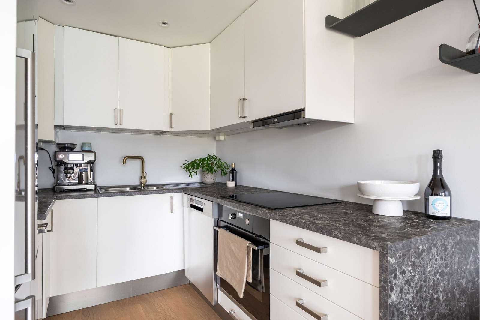 Det er integrert komfyr med nedfelt platetopp, frittstående kjøleskap med fryserdel og oppvaskmaskin. Mekanisk ventilator tilknyttet avtrekkskanal i overskap. Galleribilde