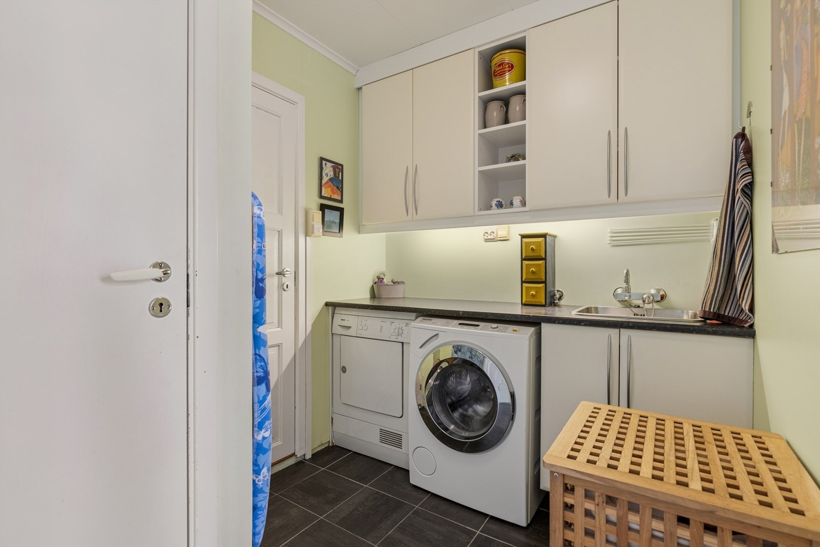 Eget vaskerom med opplegg til vaskemaskin, plass til tørketrommel og utslagsvask. Her går man ned til boligens kjeller. Galleribilde