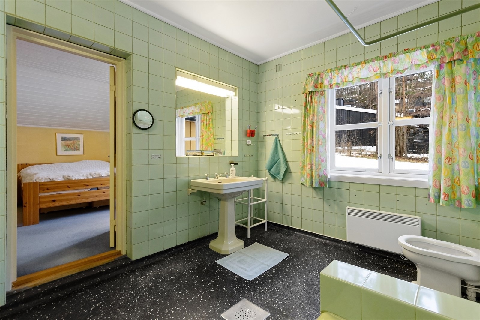 Badet er utstyrt med gulvstående toalett og servant, dusj og badekar. Galleribilde