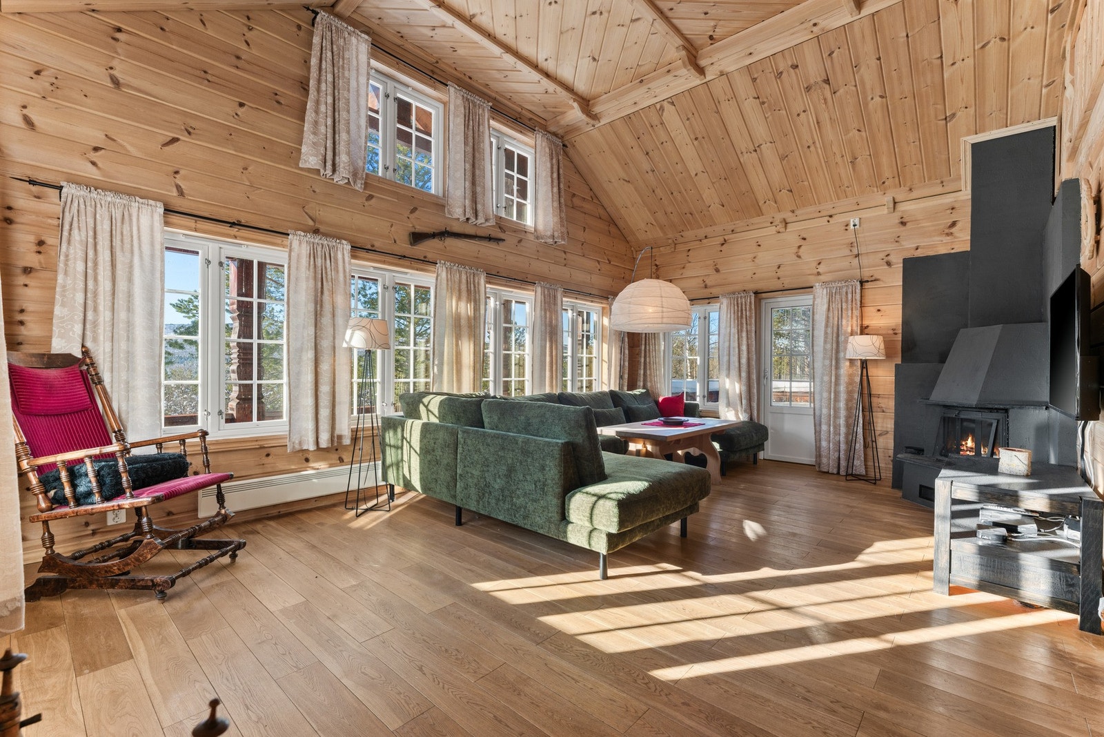 Den gode takhøyden og de store vindusflatene slipper inn rikelig med dagslys og gir stua en luftig og åpen følelse. Galleribilde