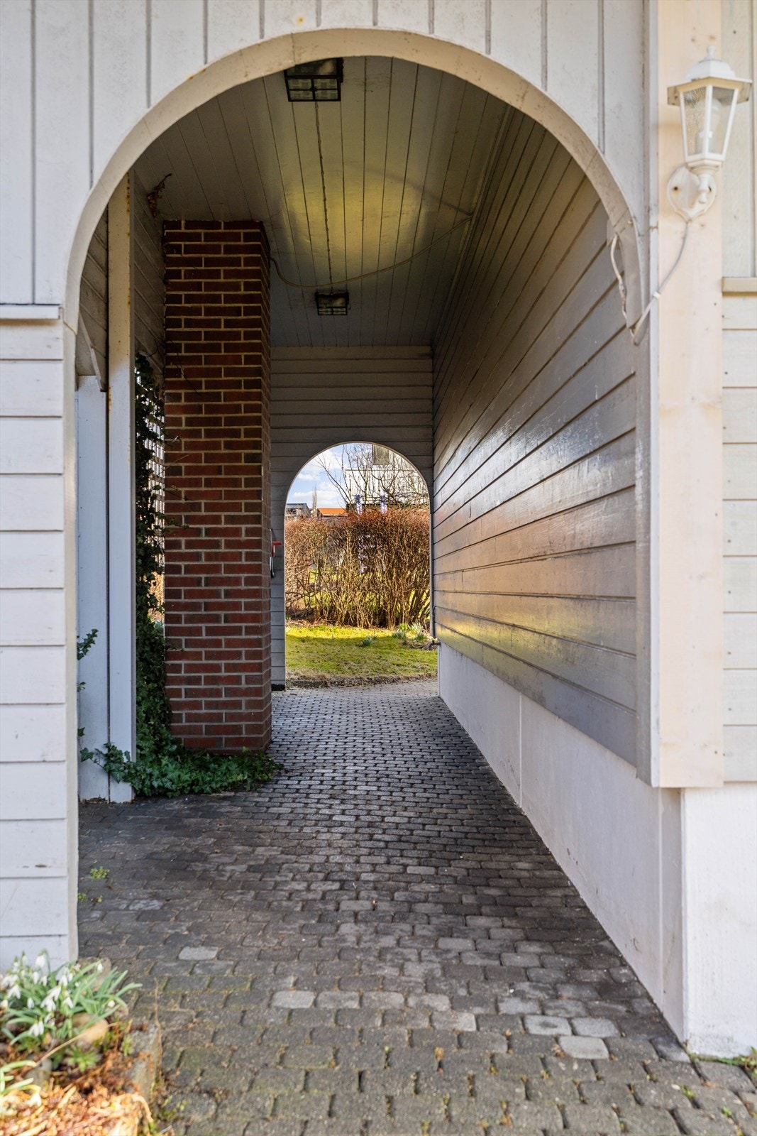 Overbygget passasje som leder fra forsiden til hagen. Galleribilde