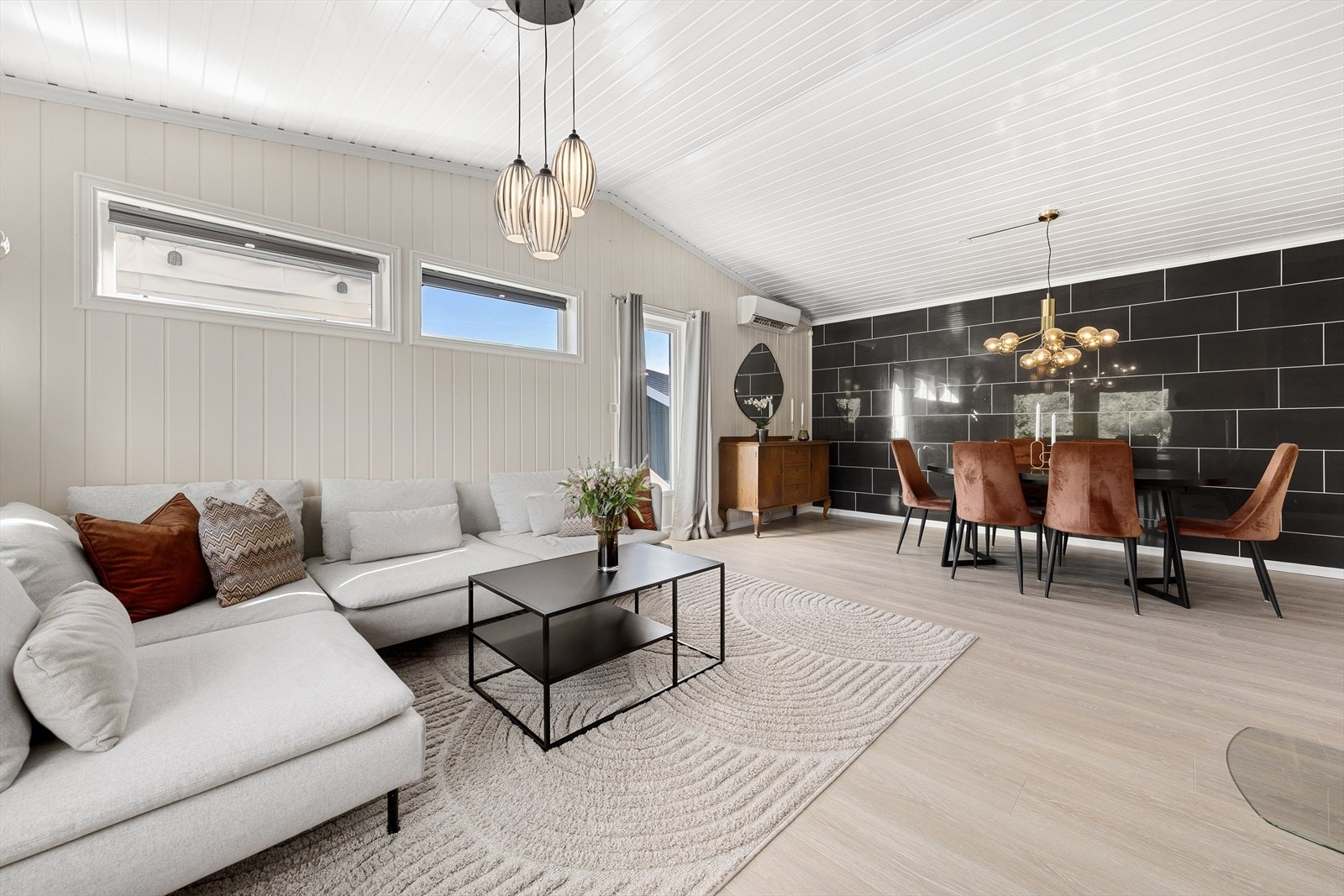 Stilren og innbydende stue i 1.etasje med 1-stavs laminat på gulv og panel vegger malt i en dus fargetone, som gir rommet en lun følelse. Galleribilde