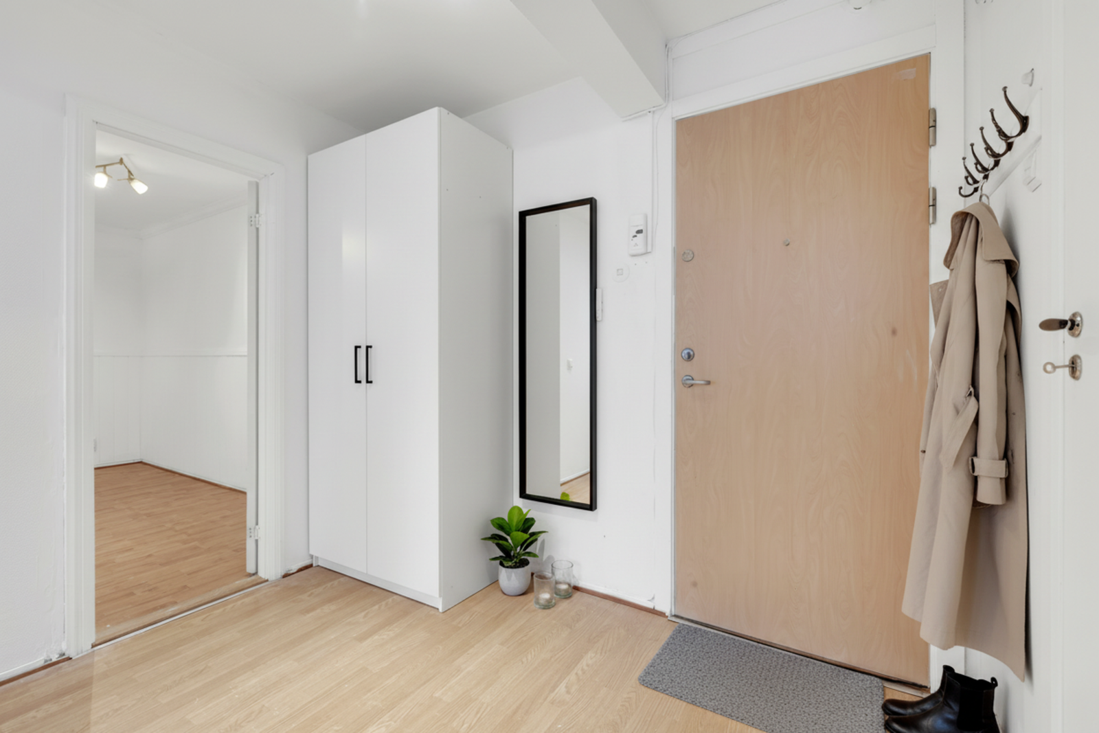 Entréen ønsker deg velkommen inn i boligen og fremstår som romslig med gode muligheter for å etablere en garderobeløsning etter eget ønske. (Bildet er digitalt stylet.) Galleribilde
