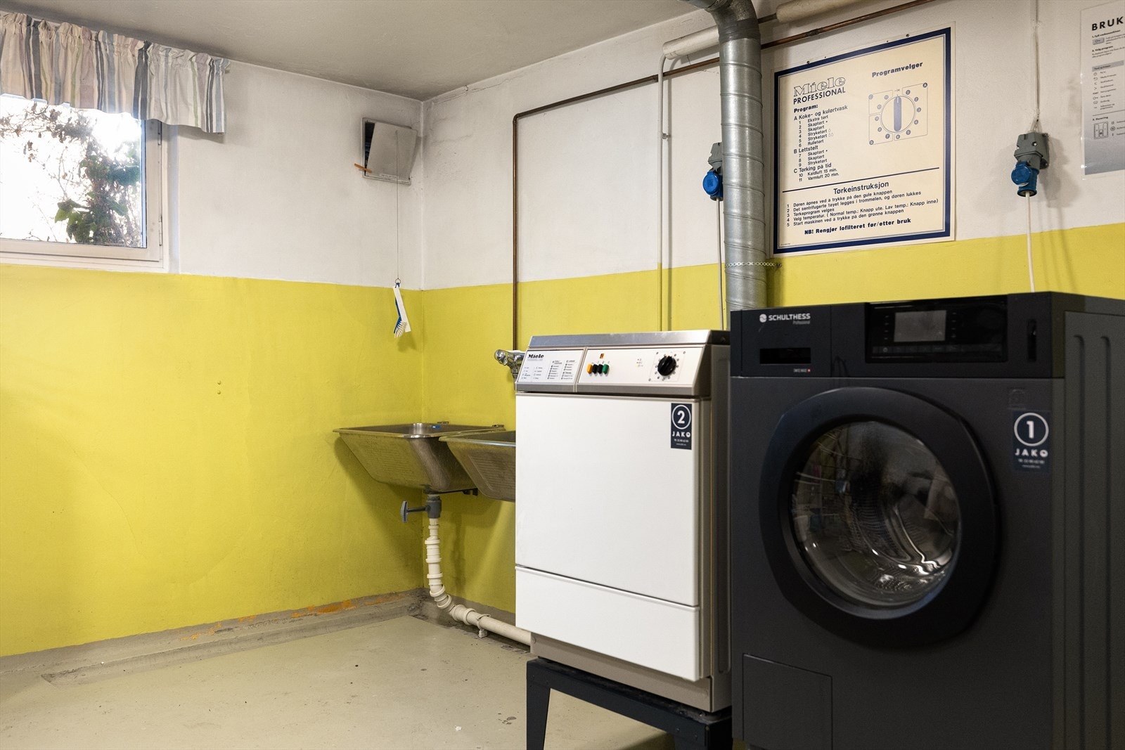 Bygget har vaskekjeller i forbindelse med inngangspartiet. Store og effektive industrimaskiner. Galleribilde