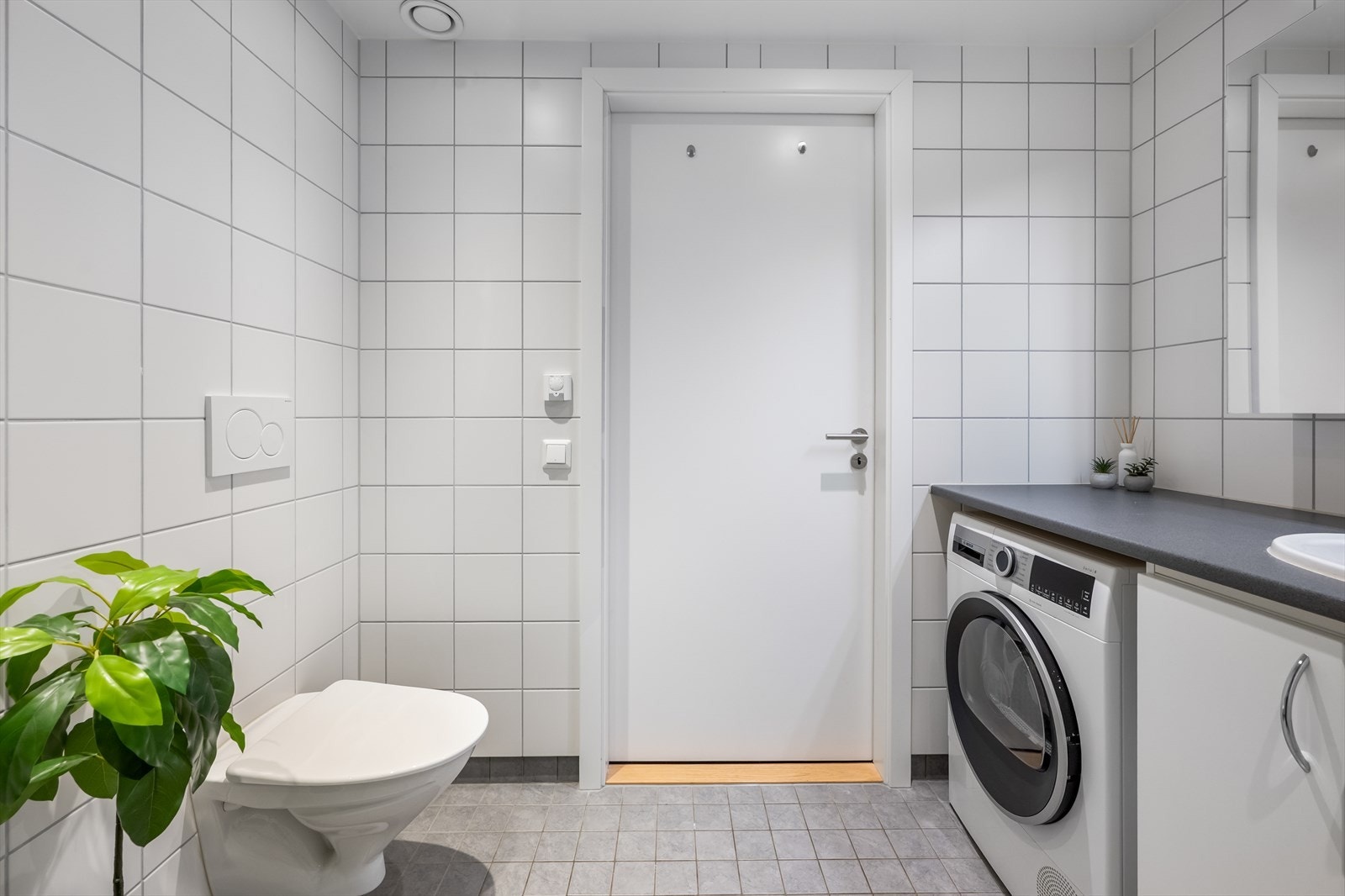 Badet er utstyrt med veggmontert toalett og en praktisk baderomsinnredning med nedfelt servant og speilskap. Galleribilde