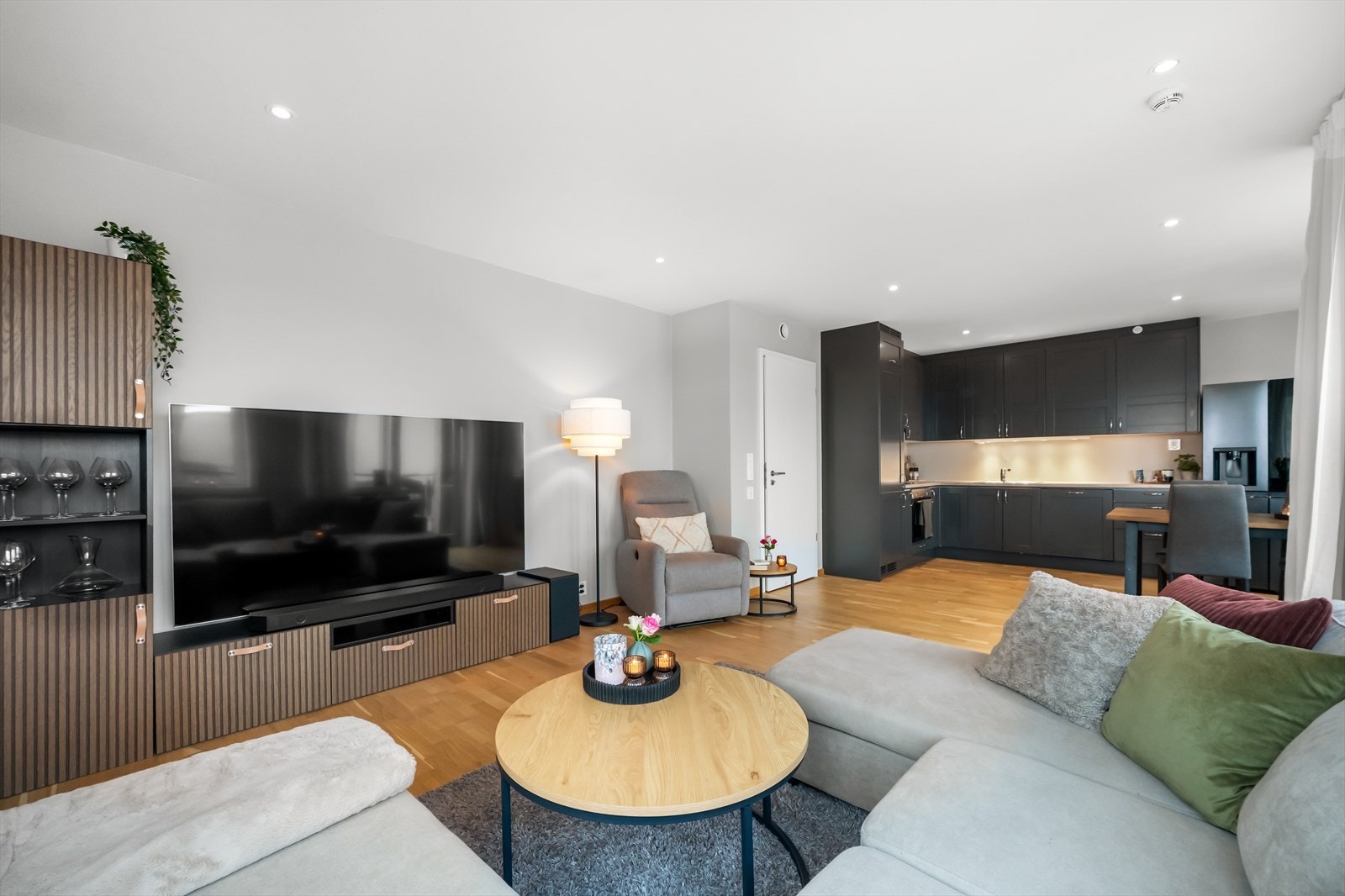 Leilighetens sosiale sone kombinerer stue og kjøkken i en åpen løsning på ca. 33 m², med gjennomgående parkett og vannbåren gulvvarme. Galleribilde