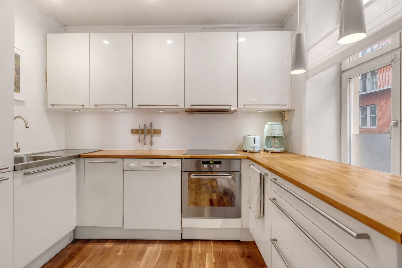 Kjøkkeninnredning med glatte fronter og integrerte hvitevarer. Galleribilde