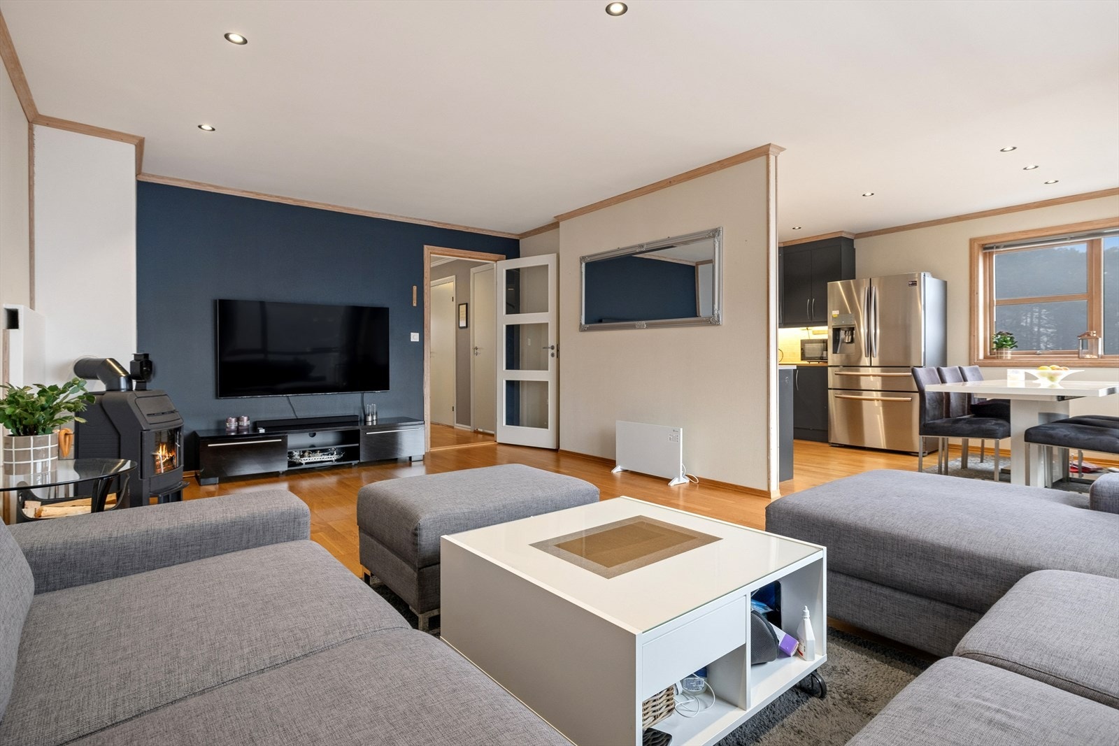 En flott dyp blå kontrastvegg og en elegant kjøkkeninnredning sprøytemalt i mørk grå tone skaper en god romfølelse. Galleribilde