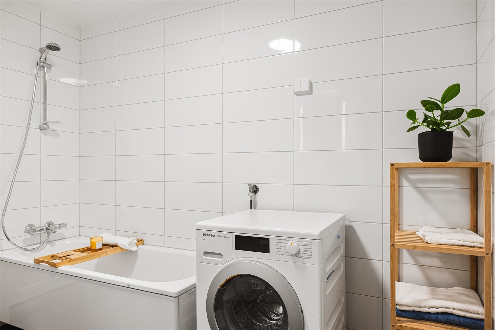 Badet er utstyrt med toalett, badekar og baderomsinnredning med skuffer, servant med ettgreps blandebatteri og speil med belysning. Galleribilde