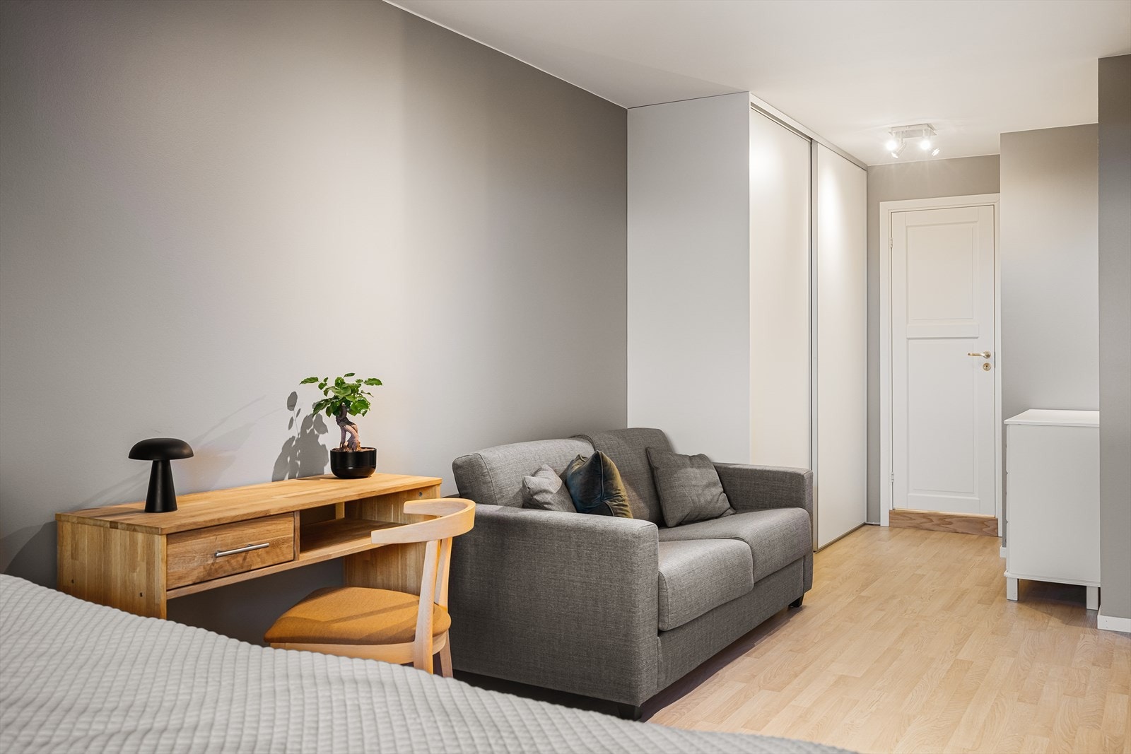 Det er god plass til dobbeltseng med tilhørende nattbord og garderobeskap. I tillegg er det plass til både skrivepult og sofa. Galleribilde