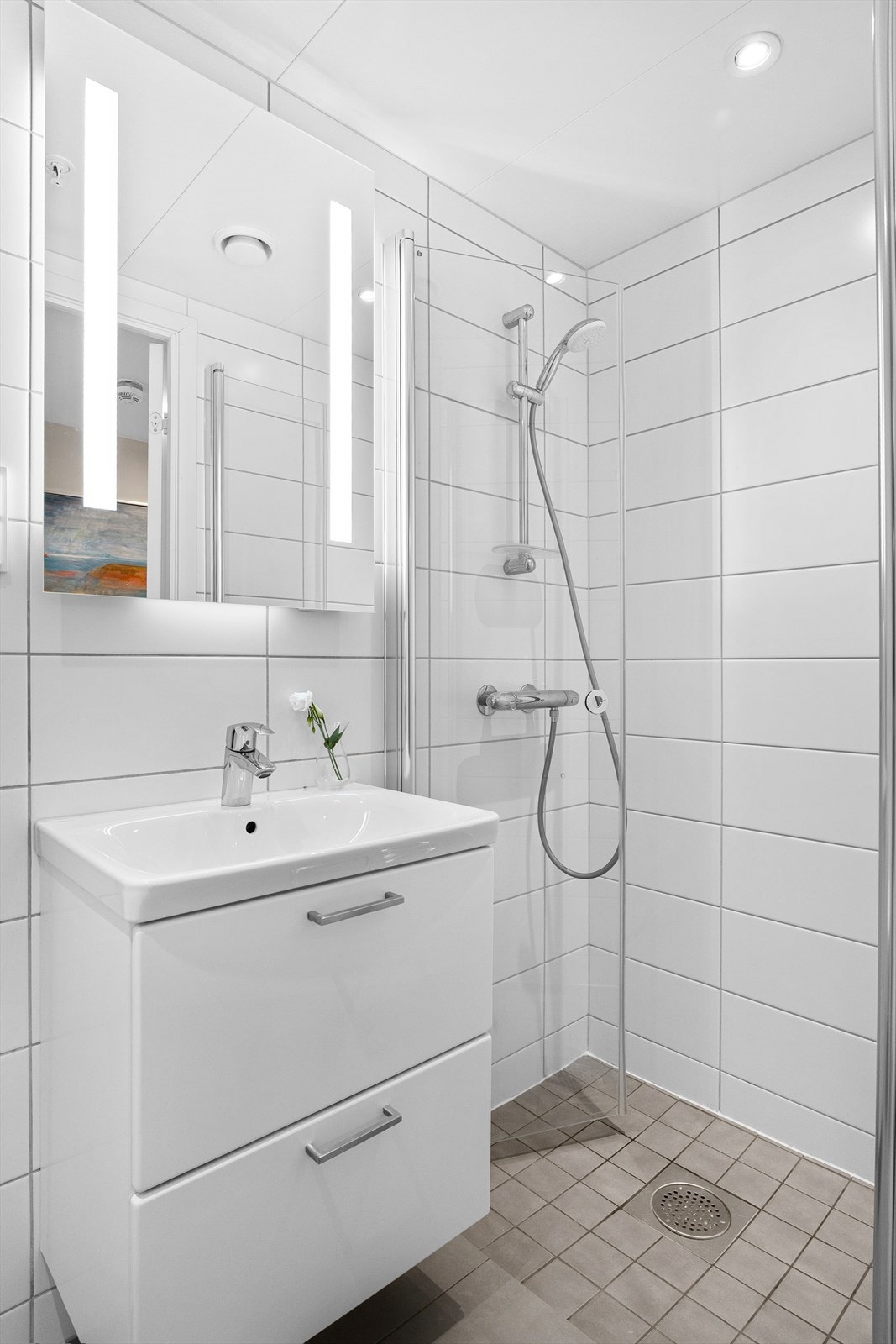 Boligens andre bad er innredet med servant med innredning, speil m/lys og dusjhjørne med skyvbar glassdør. Galleribilde