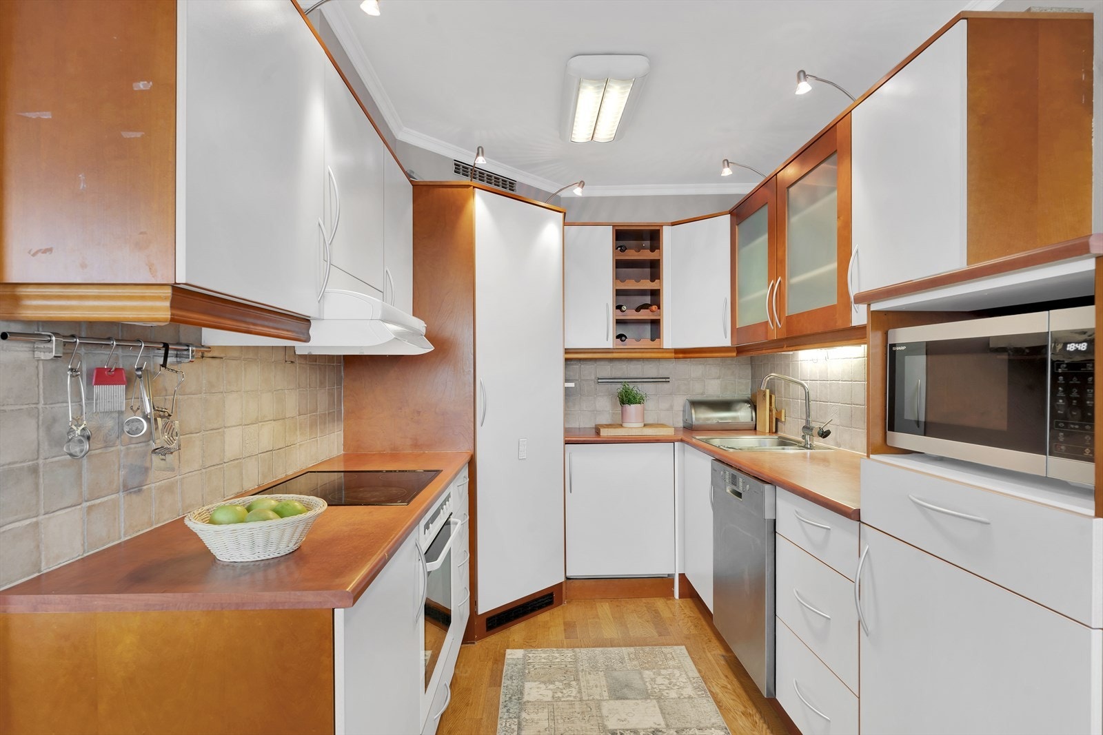 Flott kjøkken med glatte fronter og pene fliser over benkeplaten. Galleribilde