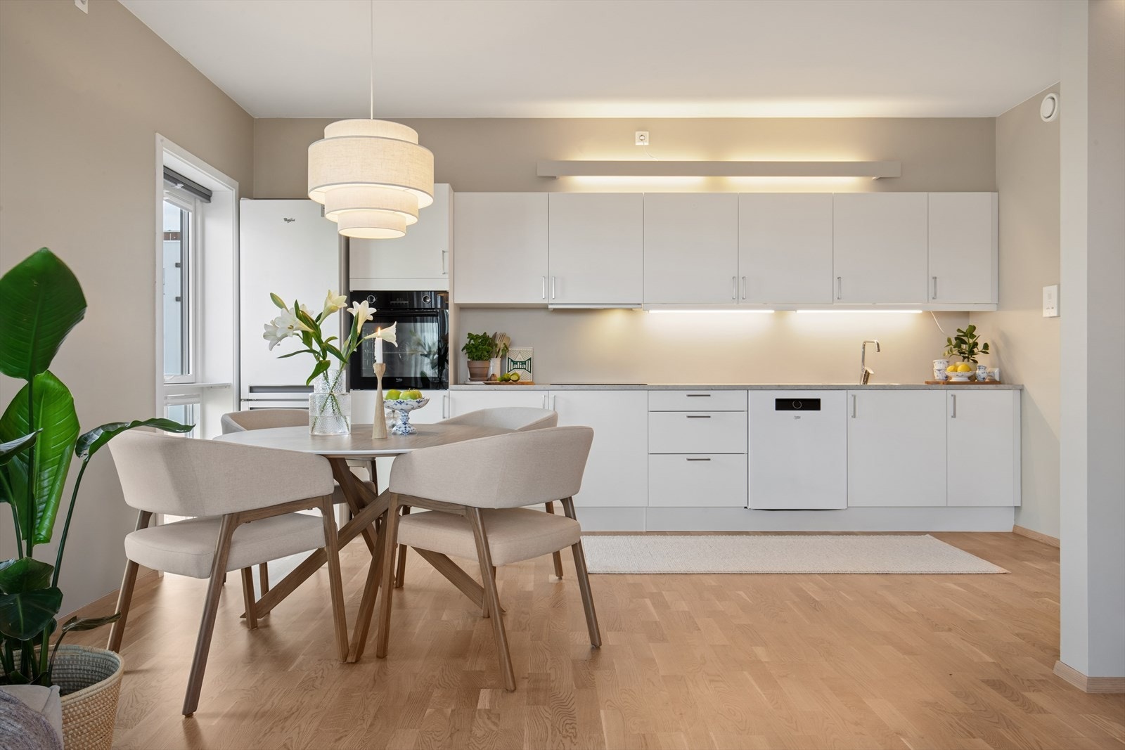 Kjøkkenet er nøytralt og er utstyrt med mye skap- og benkeplass Galleribilde