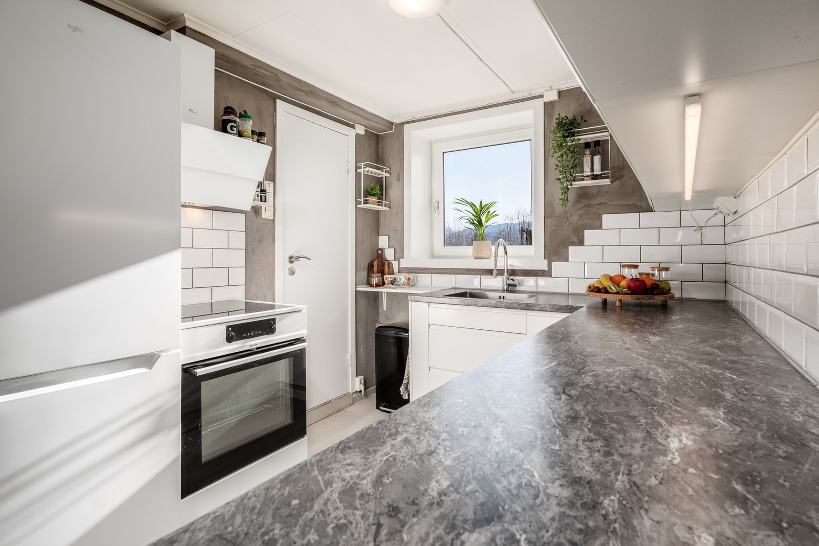 Kjøkkenet byr på god arbeidsplass på benk, legg også merke til benkebelysningen under skap. Galleribilde