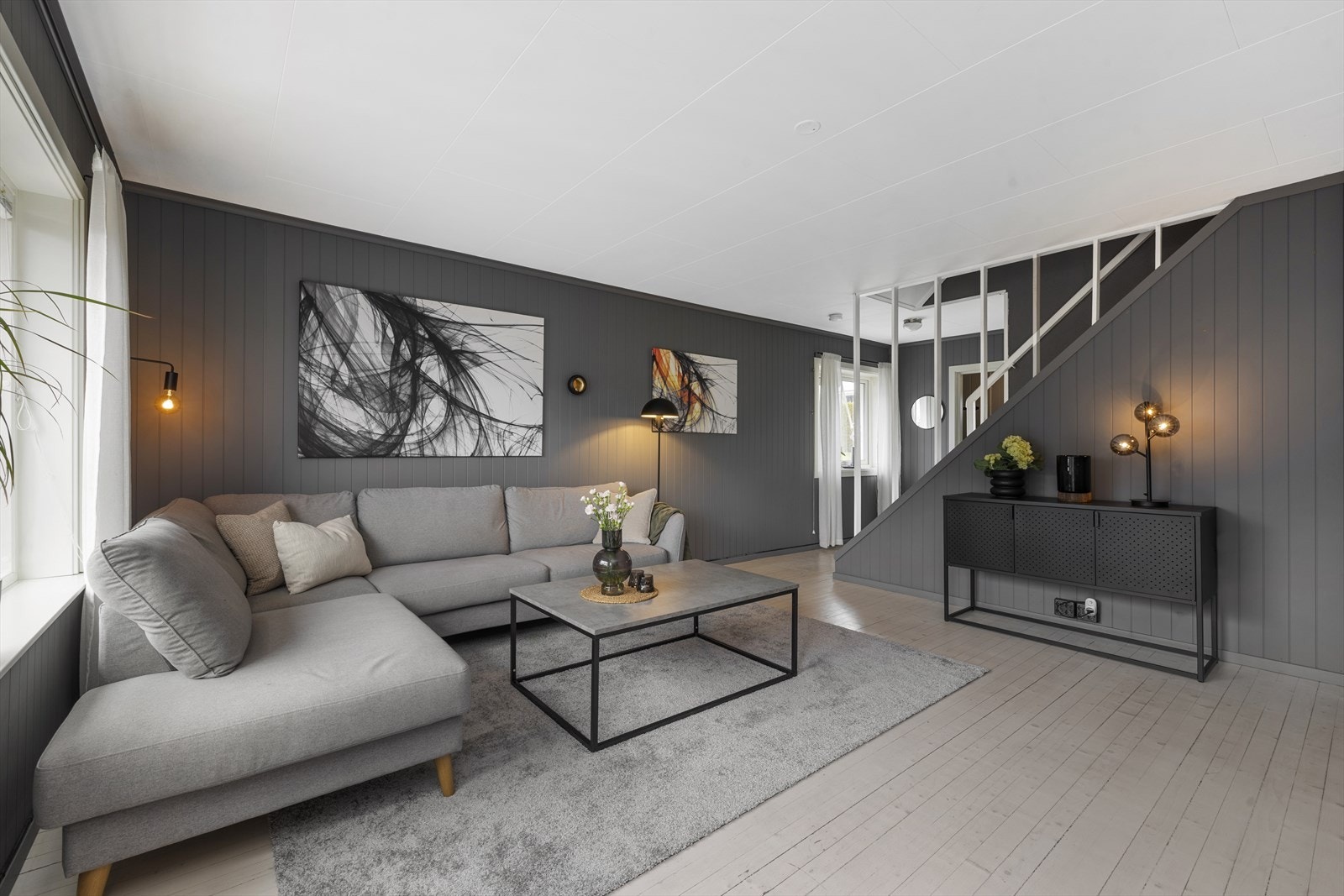 Lun og trivelig stue med mørk farge på vegger og tregulv Galleribilde