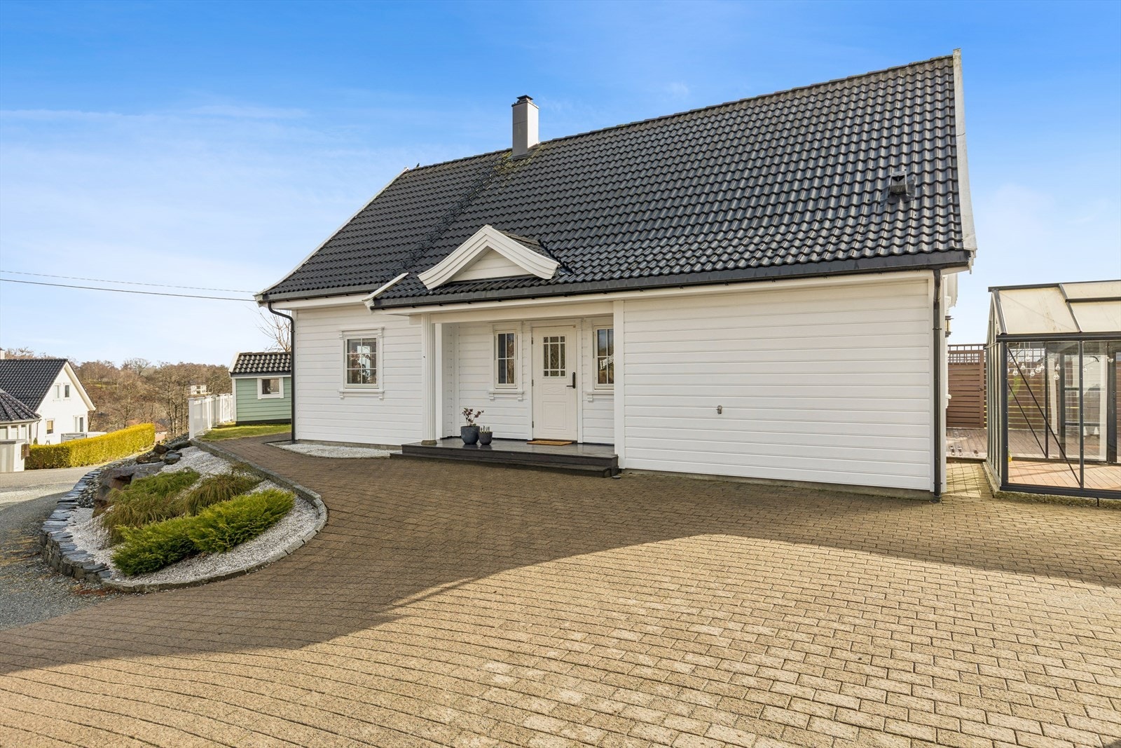 Pent opparbeidet gårdsplass med belegningsstein og enkel adkomst til inngangspartiet. Galleribilde