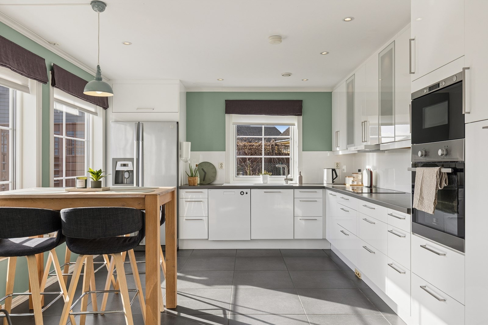 Kjøkkenet har en innholdsrik innredning med hvite, glatte fronter og tidsriktige hvitevarer. Galleribilde