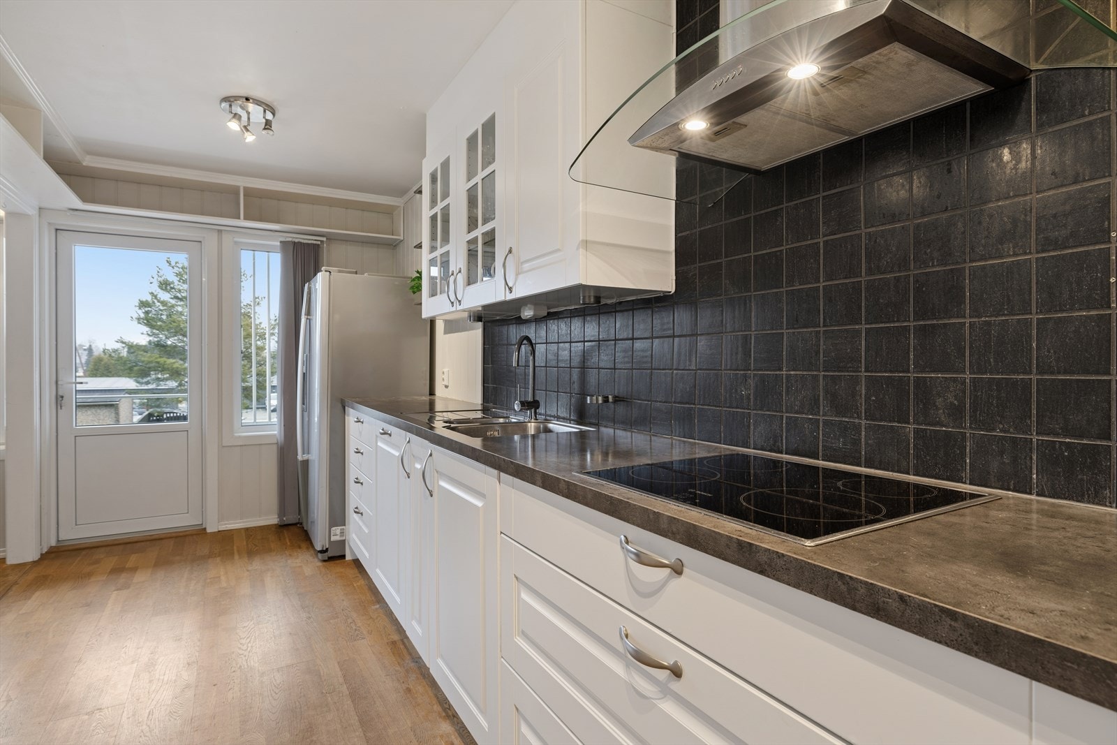 Kjøkkenet har hvite profilerte fronter og laminat benkeplate Galleribilde