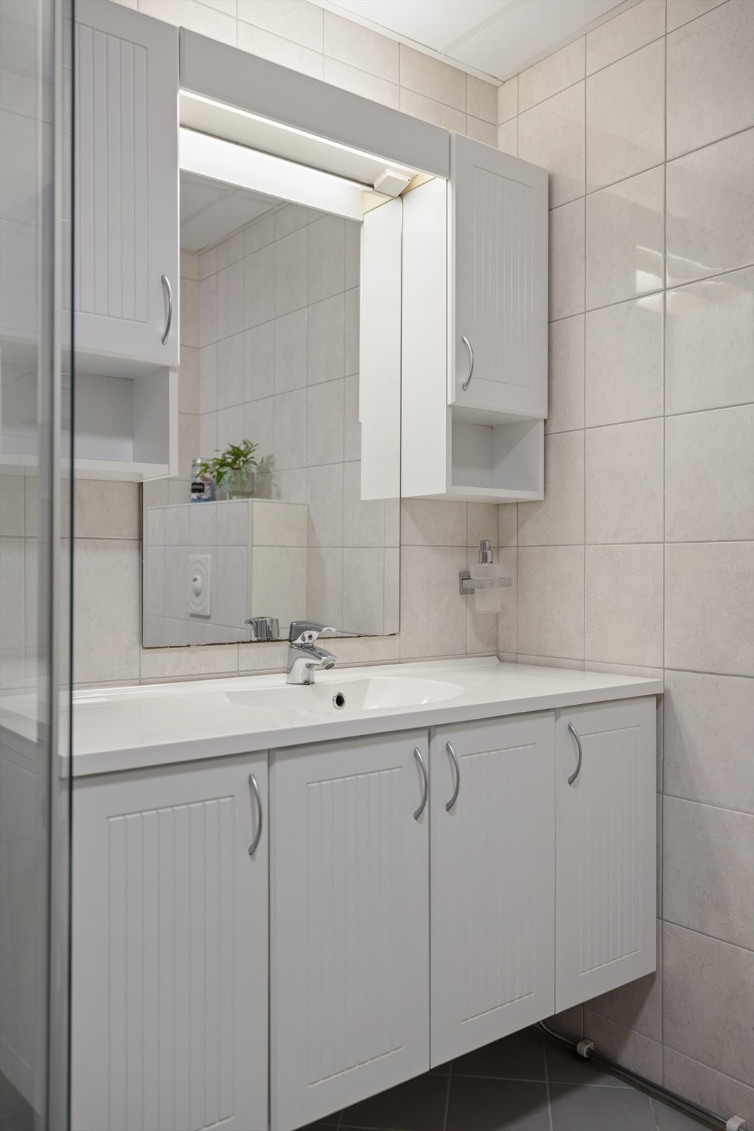 Badet er innredet med servant, dusjkabinett, wc og opplegg for vaskemaskin Galleribilde