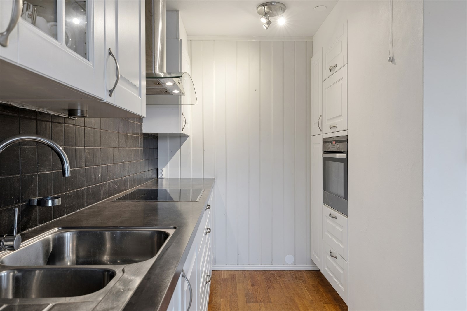 Integrerte hvitevarer som oppvaskmaskin, induksjonstopp og stekeovn. Galleribilde