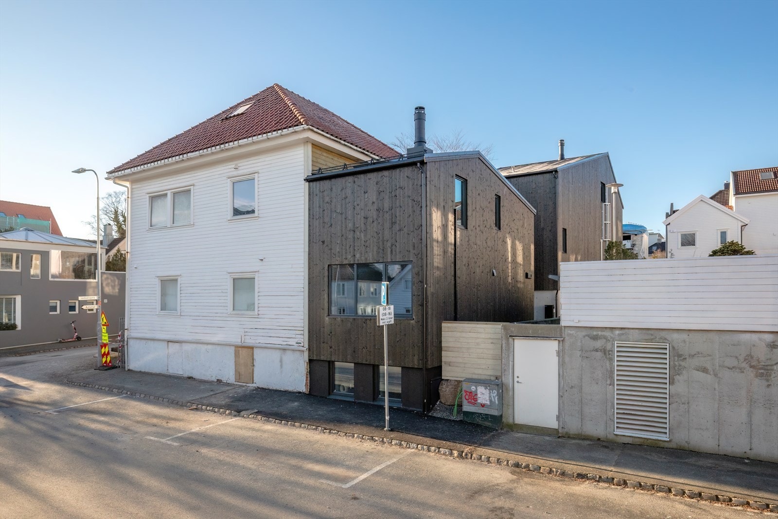 Boligen utgjør det moderne, svarte tilbygget, som gir et stilrent uttrykk og en fin kontrast til den øvrige bebyggelsen. Galleribilde