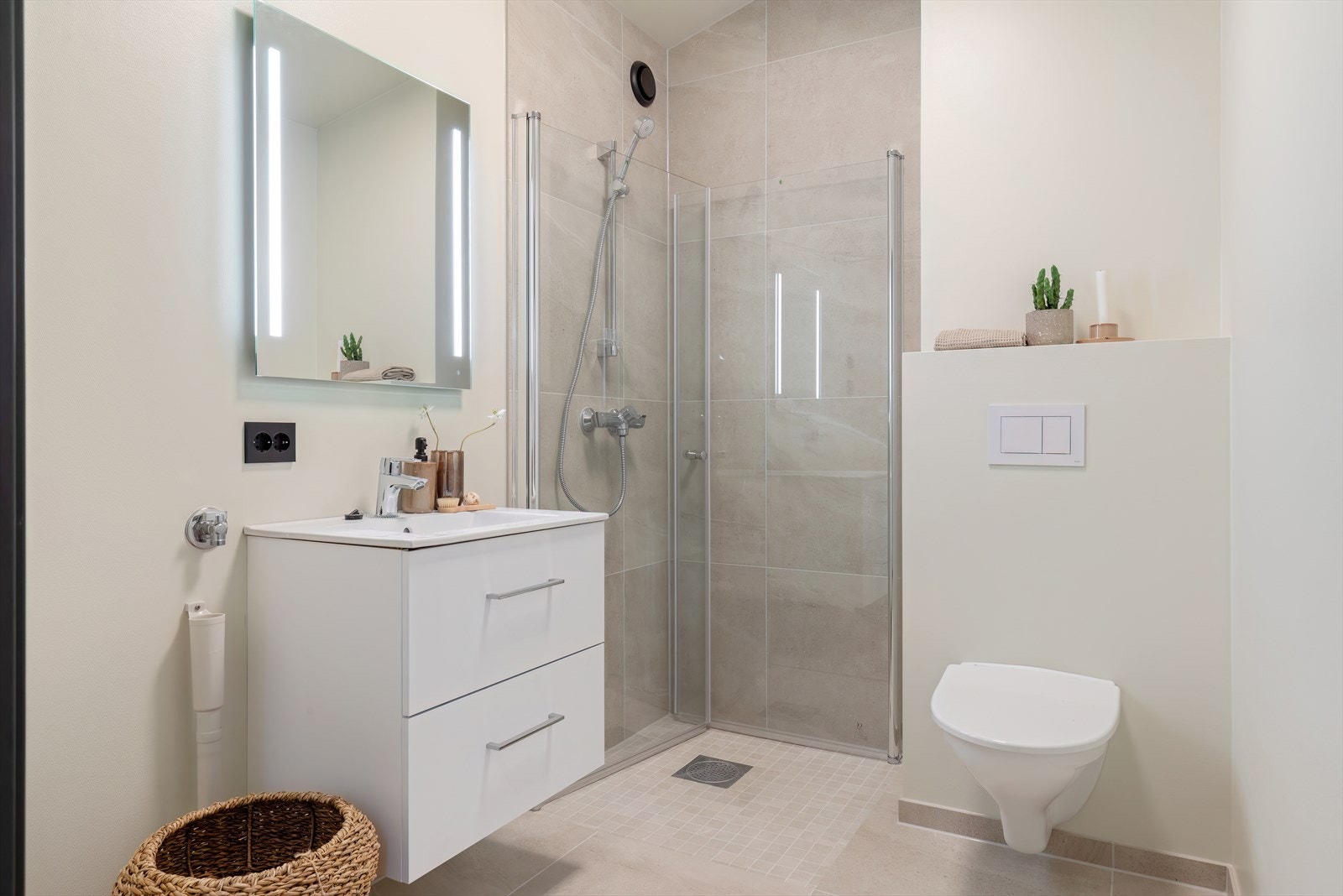 Delikat, helfliset bad med dusjsone og vegghengt toalett. Galleribilde