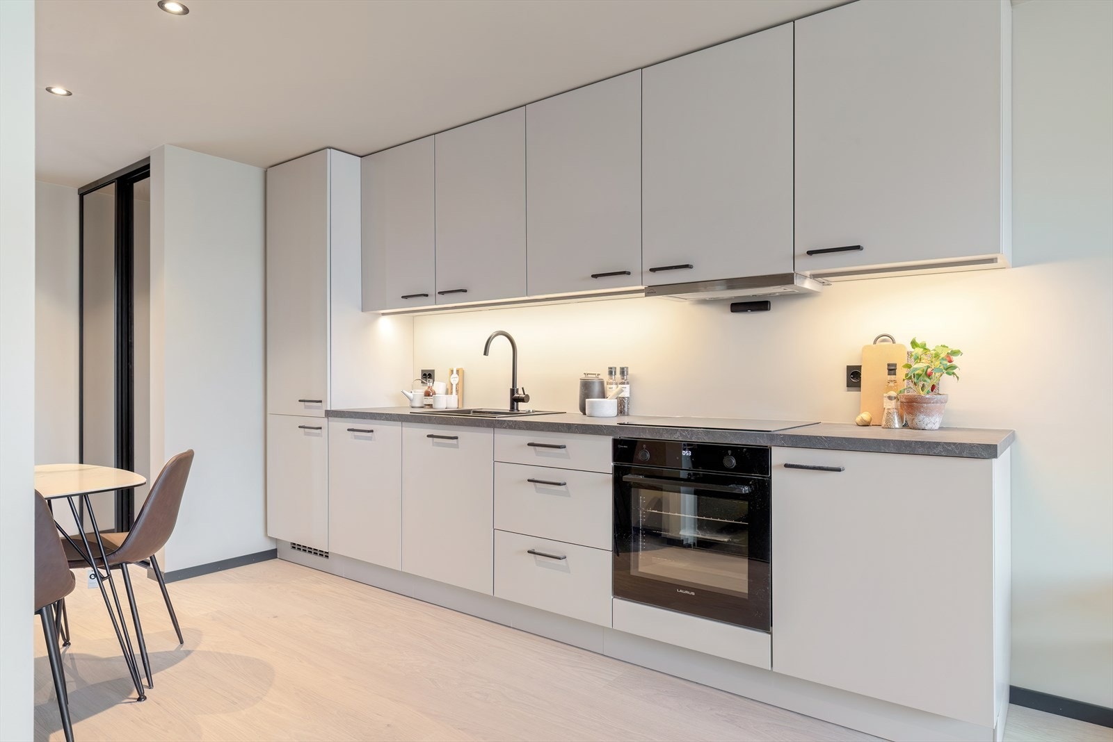 Stilrent kjøkken med rene linjer, integrerte løsninger og gode arbeidsflater. Galleribilde