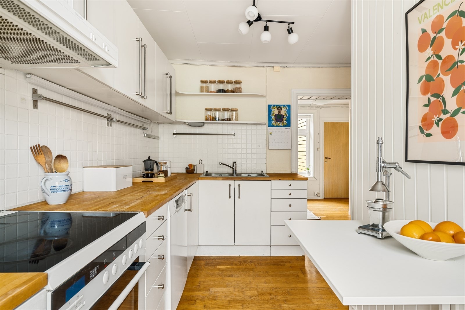 Leilighetens kjøkken er innredet i en vinkel med lyse fronter og en benkeplate som gir gode arbeidsforhold..jpg Galleribilde