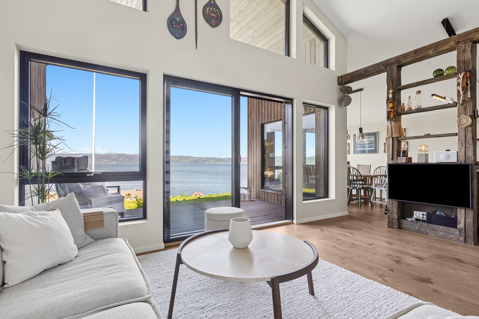 Lyst og luftig stue hvor store vindusflater rammer inn en vidstrakt fjordutsikt - et innbydende sted å slappe av og nyte naturen fra sofakroken. Galleribilde