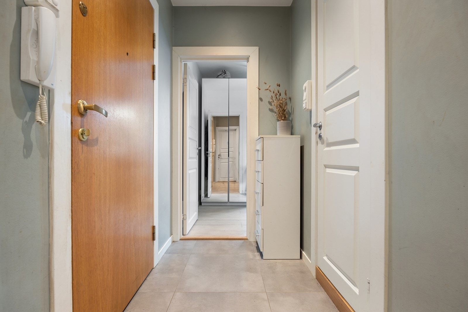 Entréen har flislagt gulv med varmekabler som gir en lun og praktisk velkomst. Galleribilde