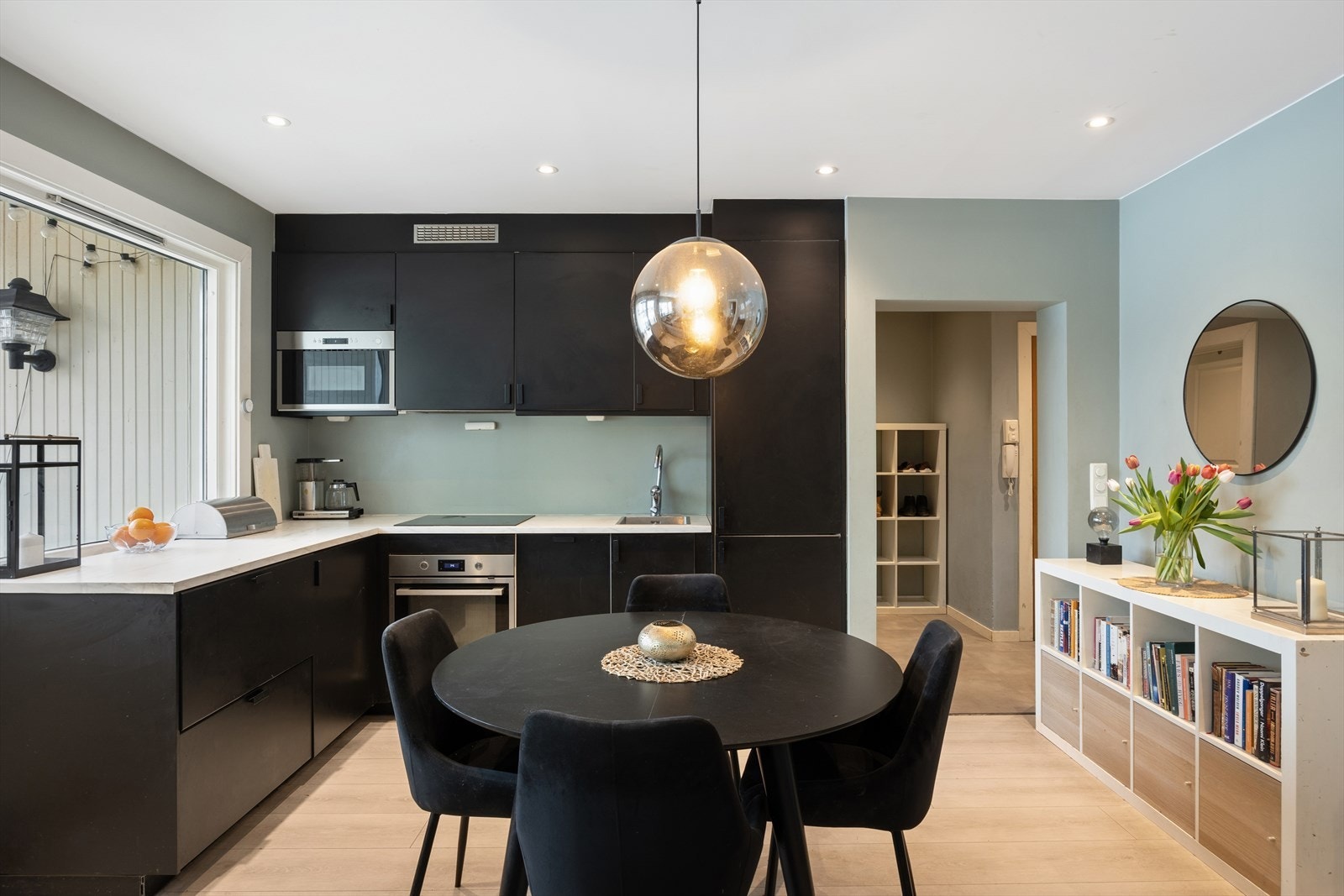 Kjøkkeninnredningen fra 2019 har sorte, glatte fronter og integrerte hvitevarer. Galleribilde