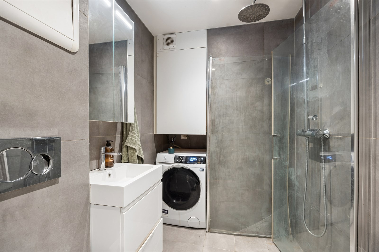 Badet er utstyrt med vegghengt toalett, hjørnedusj og opplegg for vaskemaskin. Galleribilde