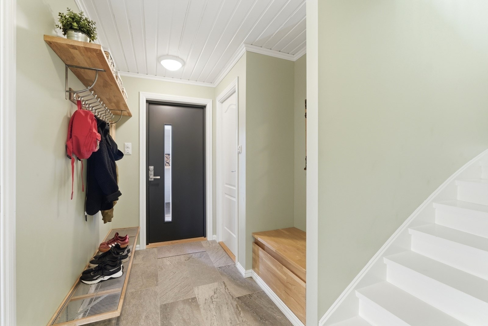 Inngangspartiet har fliser med gulvvarme lagt i 2018 og en ny, malt ytterdør fra 2020. Galleribilde