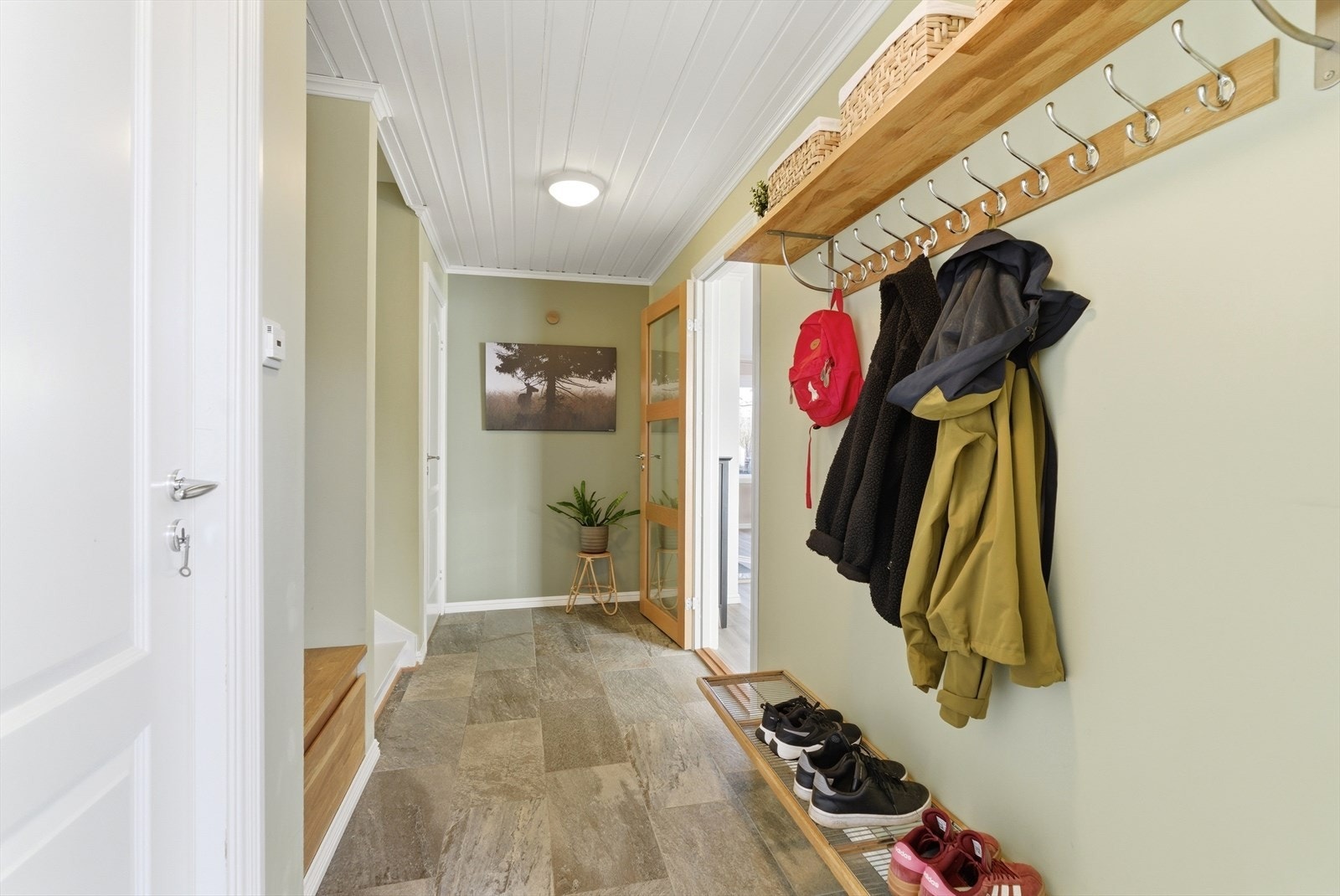 Fra gangen åpner boligen seg opp mot stuen. Varmefolie i gulvet ble installert i 2018. Galleribilde